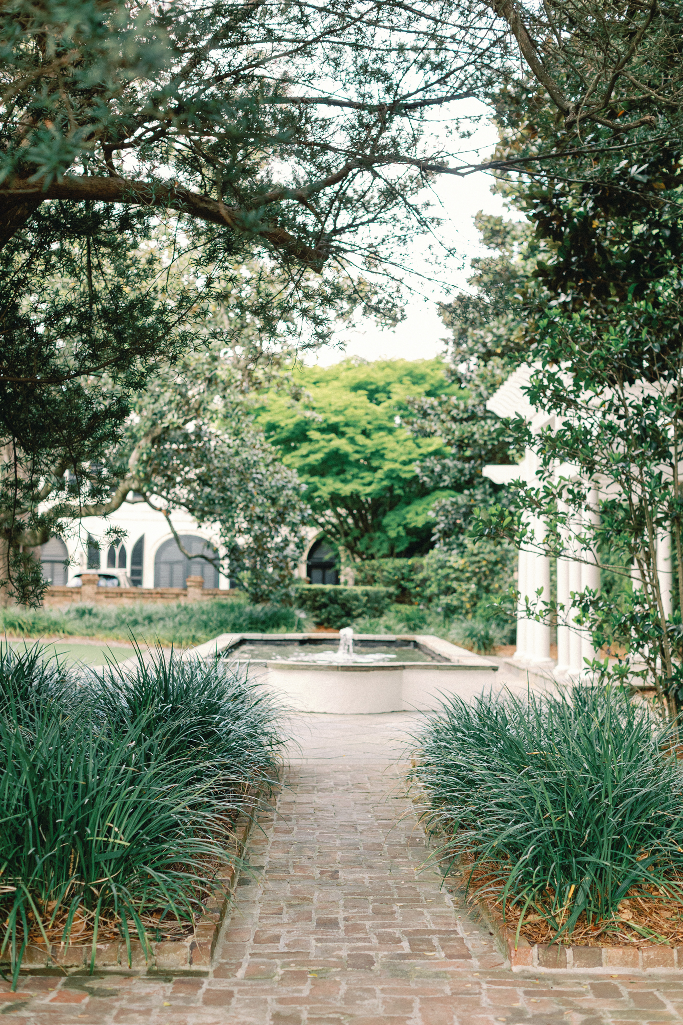 william aiken house, Brick path leads to a fountain in a formal garden with clipped hedges and a columned loggia in Charleston