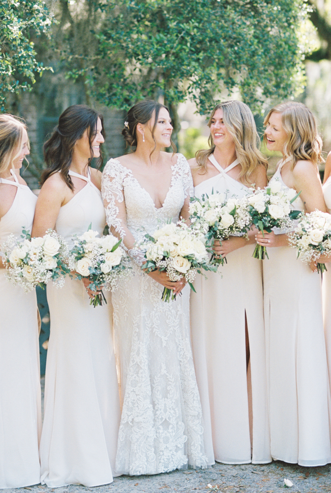 bridesmaids laughing at each other with bouquets