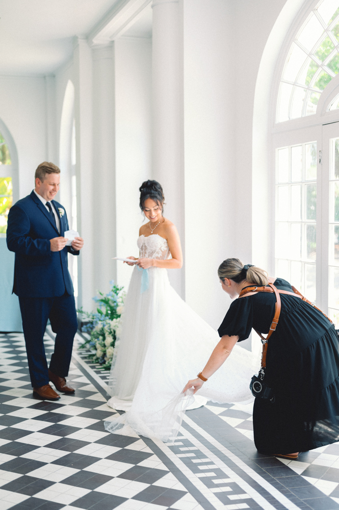 charleston wedding photographer fixing brides dress before first look