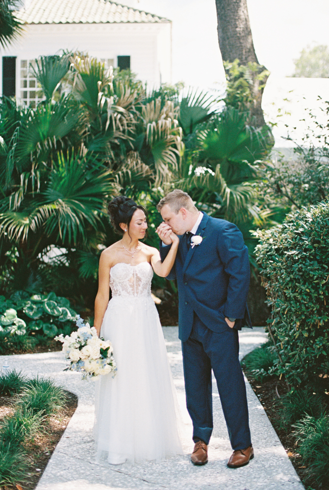 couple in front of palm trees in charleston kissing