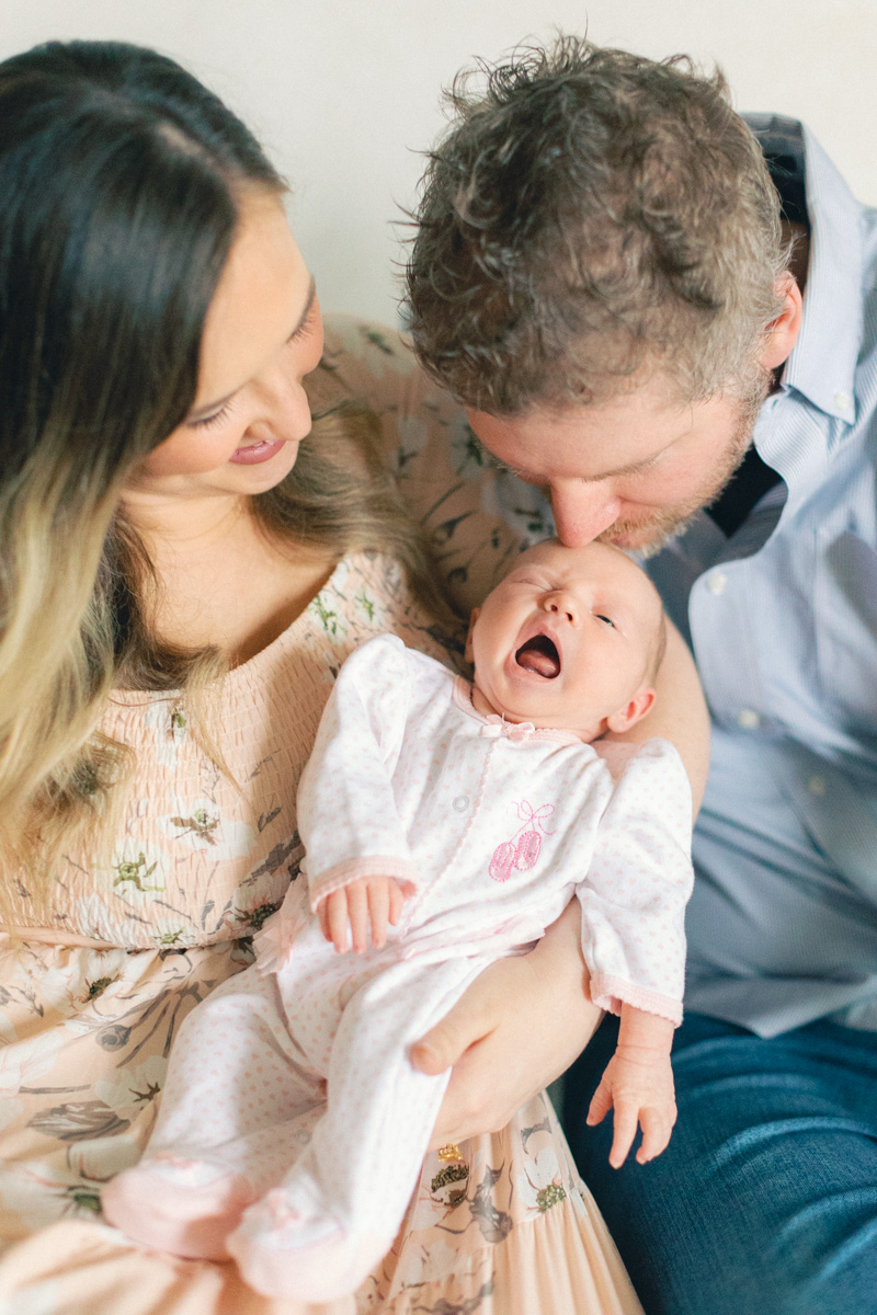 parents snuggling newborn yawning