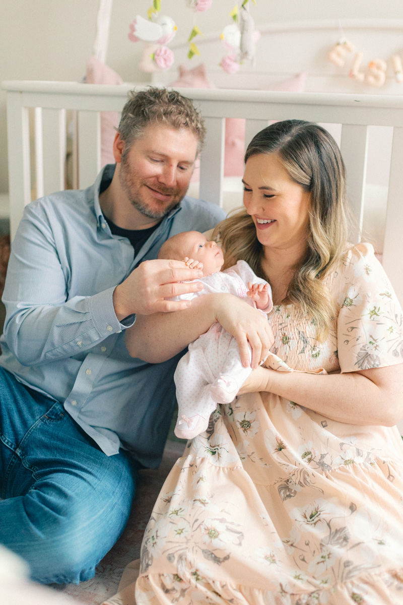 mom and dad holding newborn in nursery