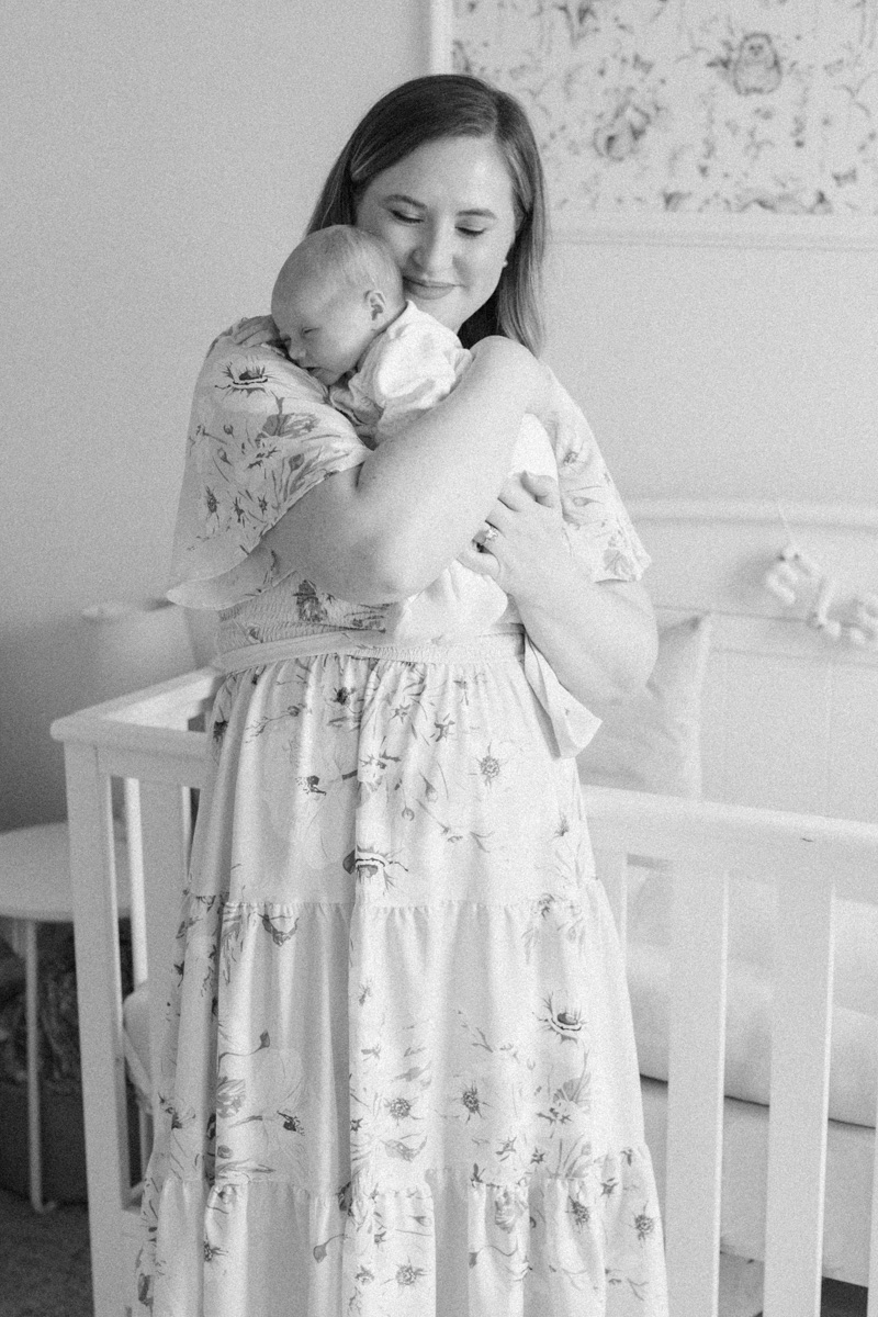 mom holding newborn baby in nursery