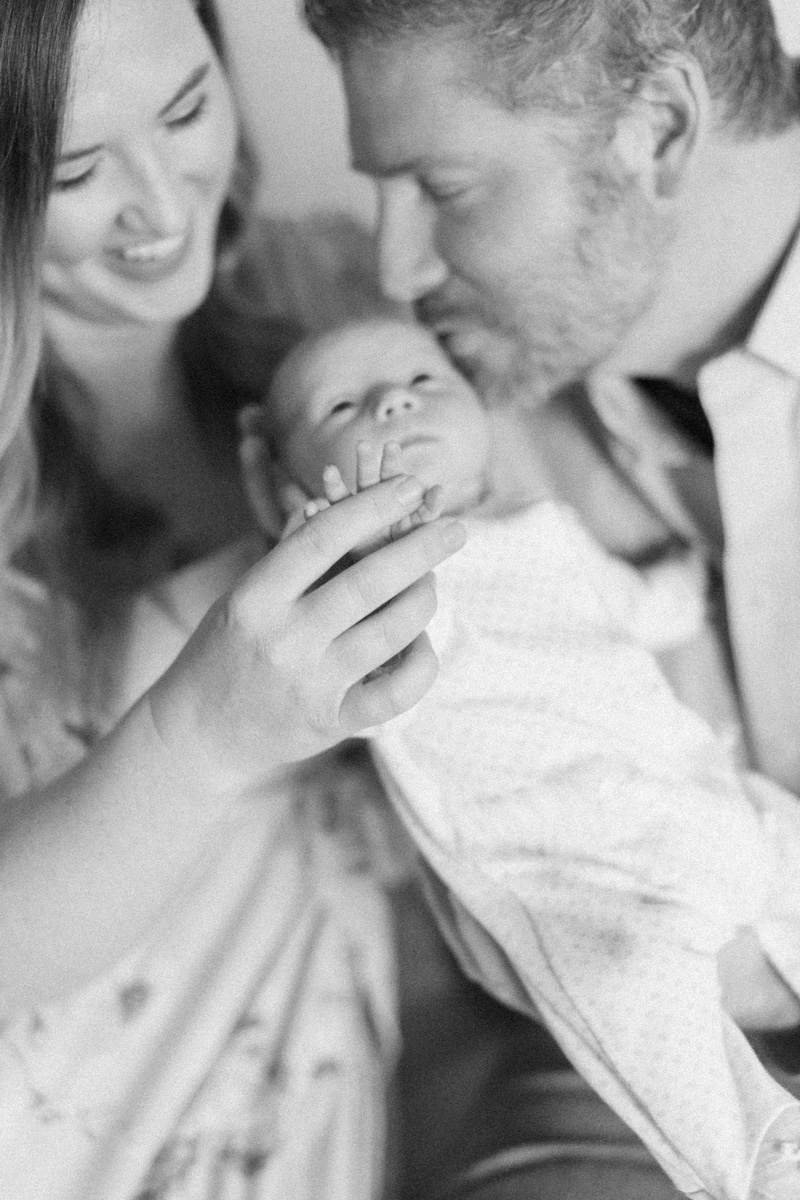 dad kissing newborn baby