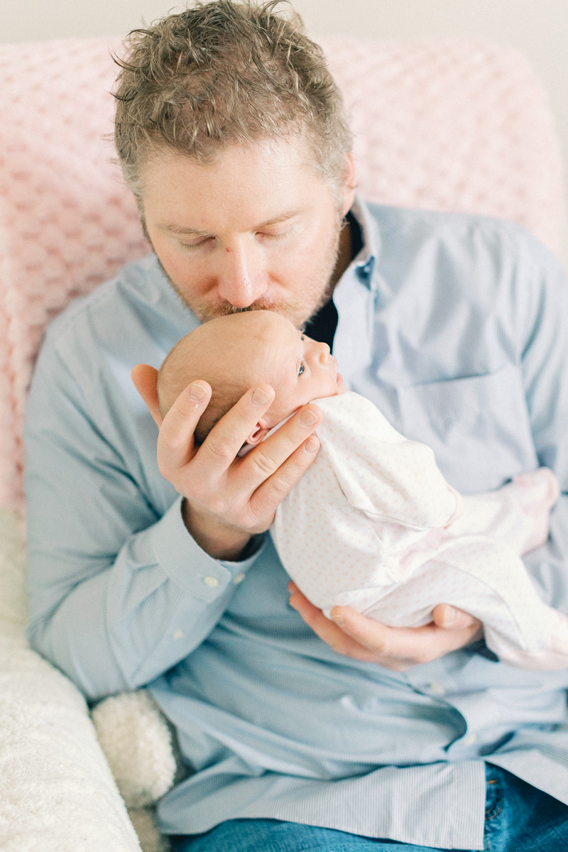 dad holding and kissing newborn