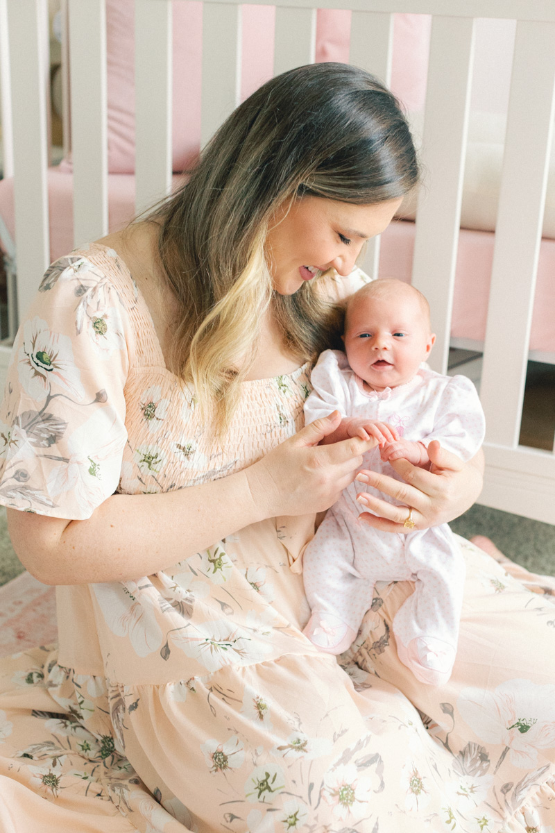 newborn baby on moms lap smiling