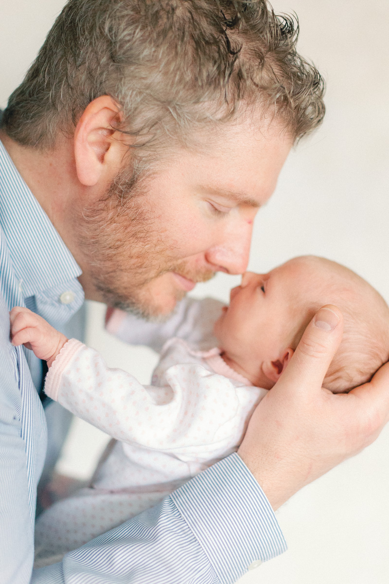 dad snuggling newborn baby