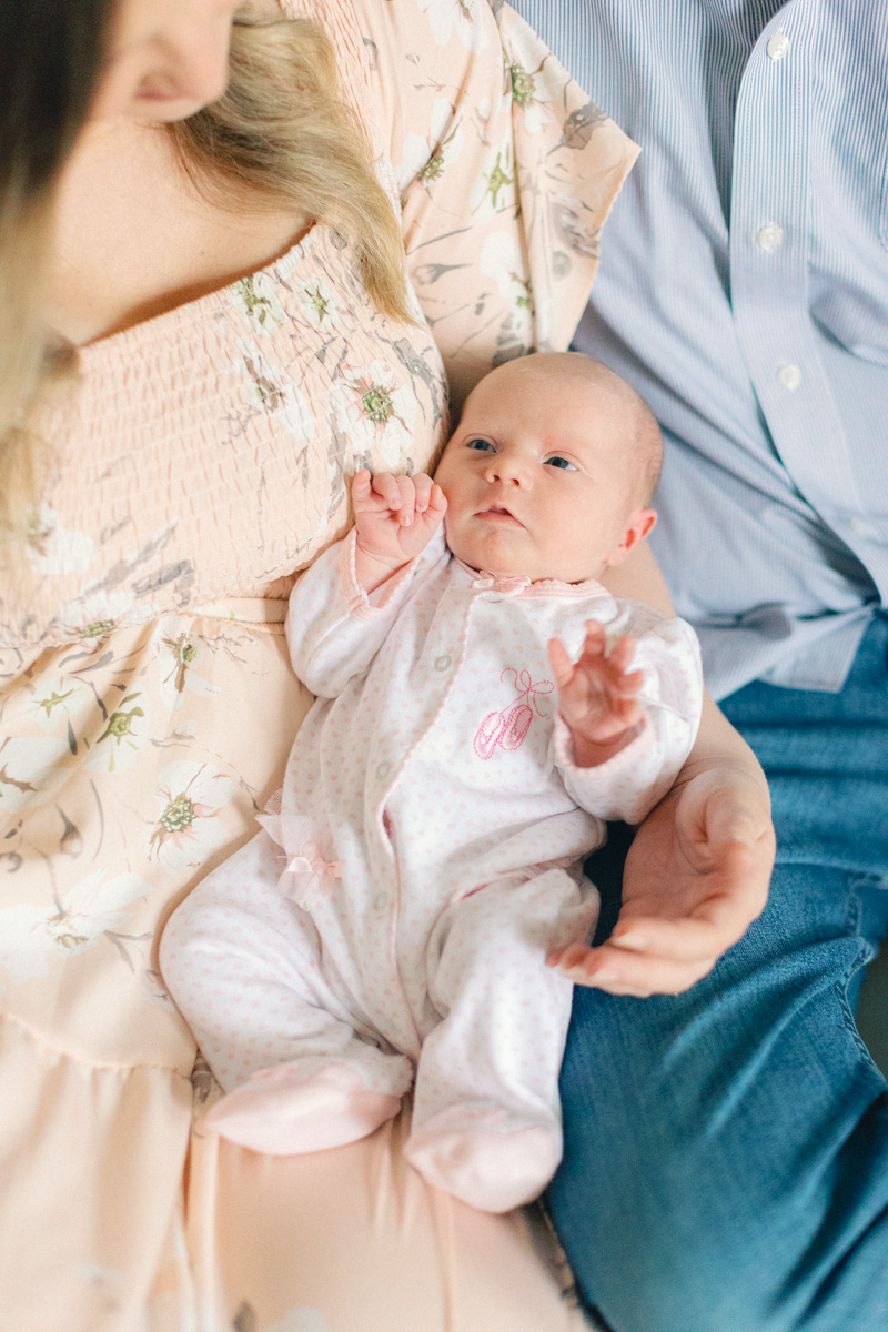 baby newborn sitting in parents lap