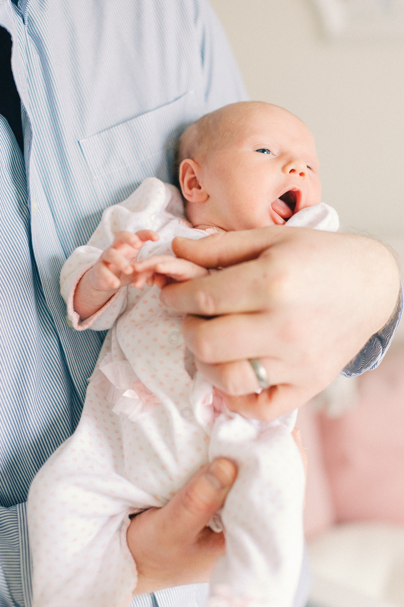 newborn baby yawning in dads arms