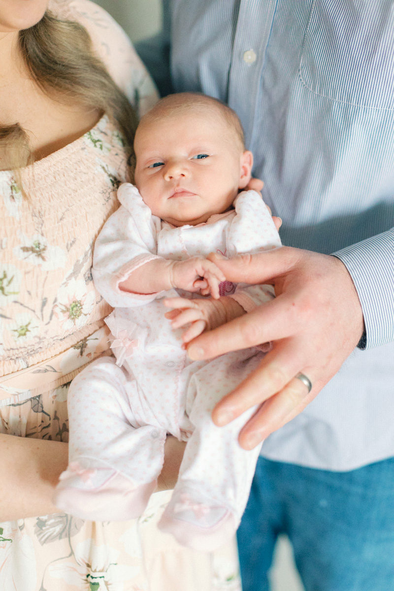 parents holding newborn baby close up