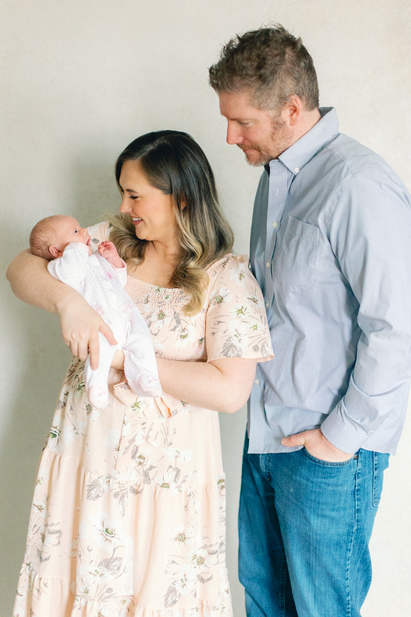 parents smiling and holding newborn baby