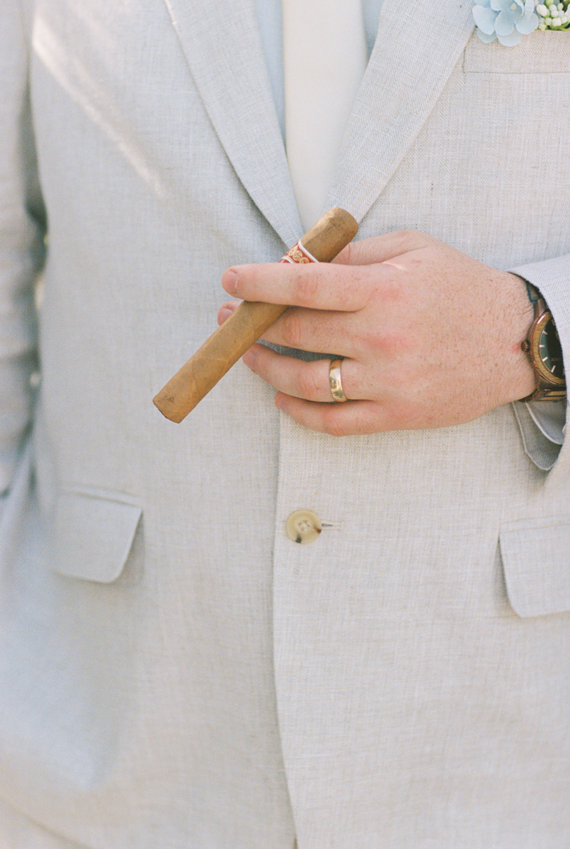 groom holding cigar