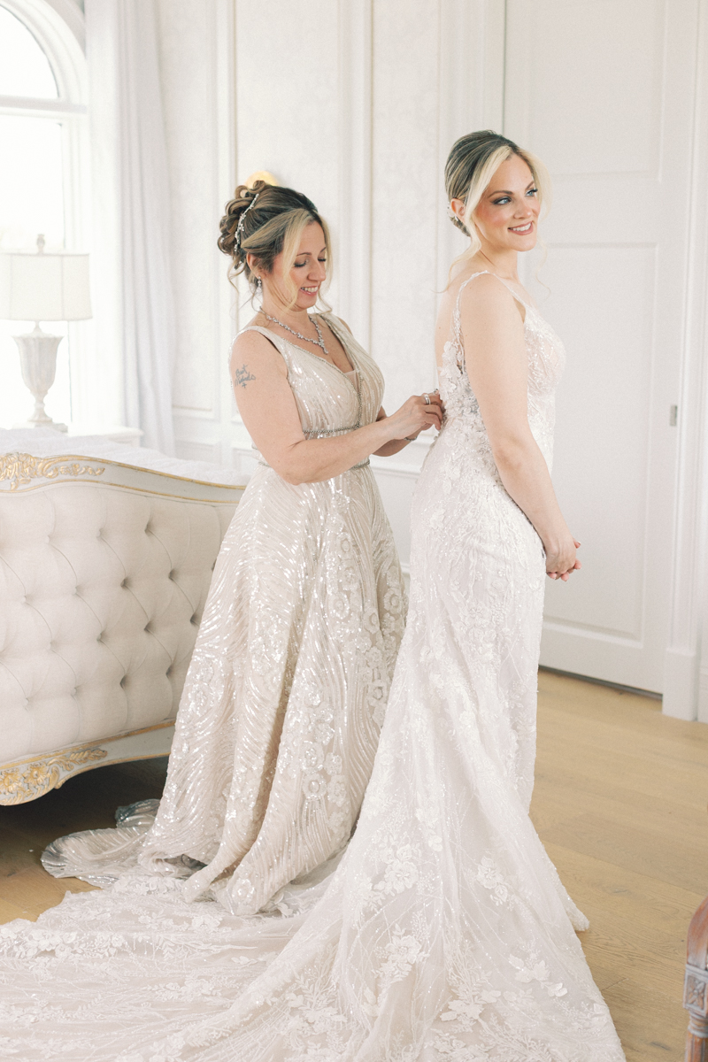 mom putting on brides dress