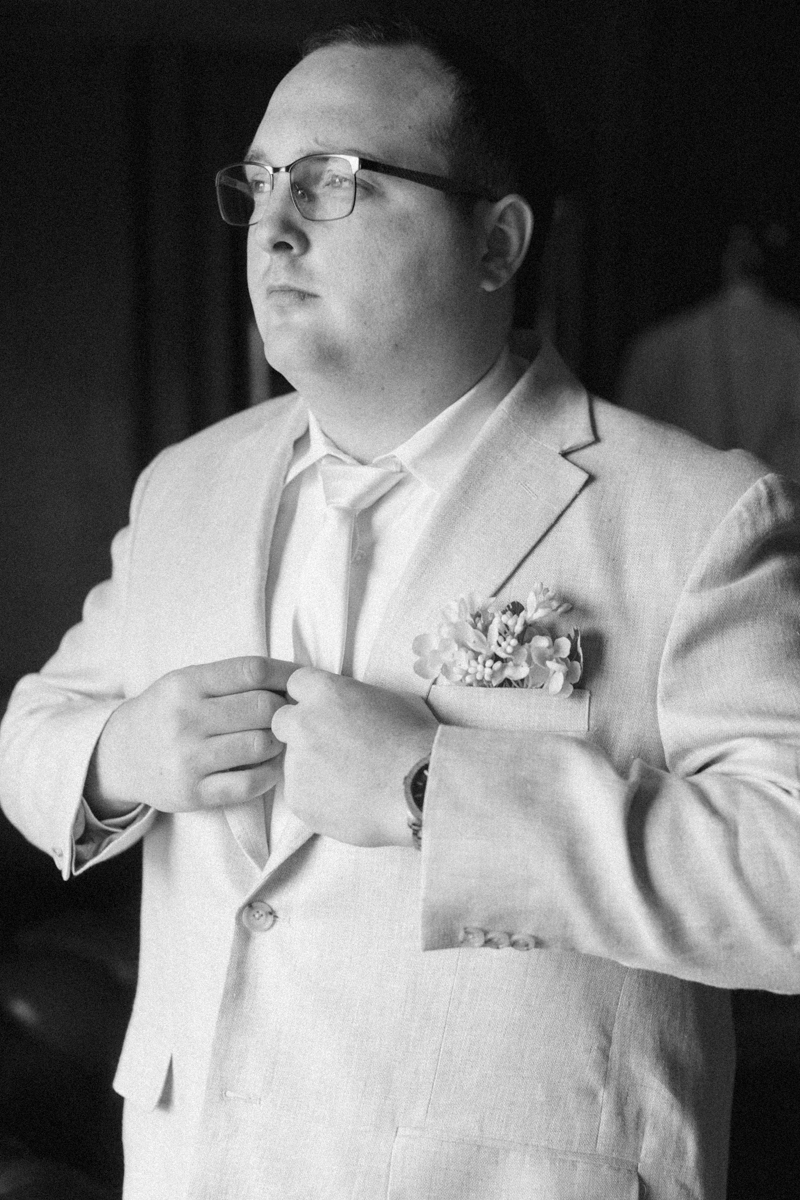 groom adjusting jacket