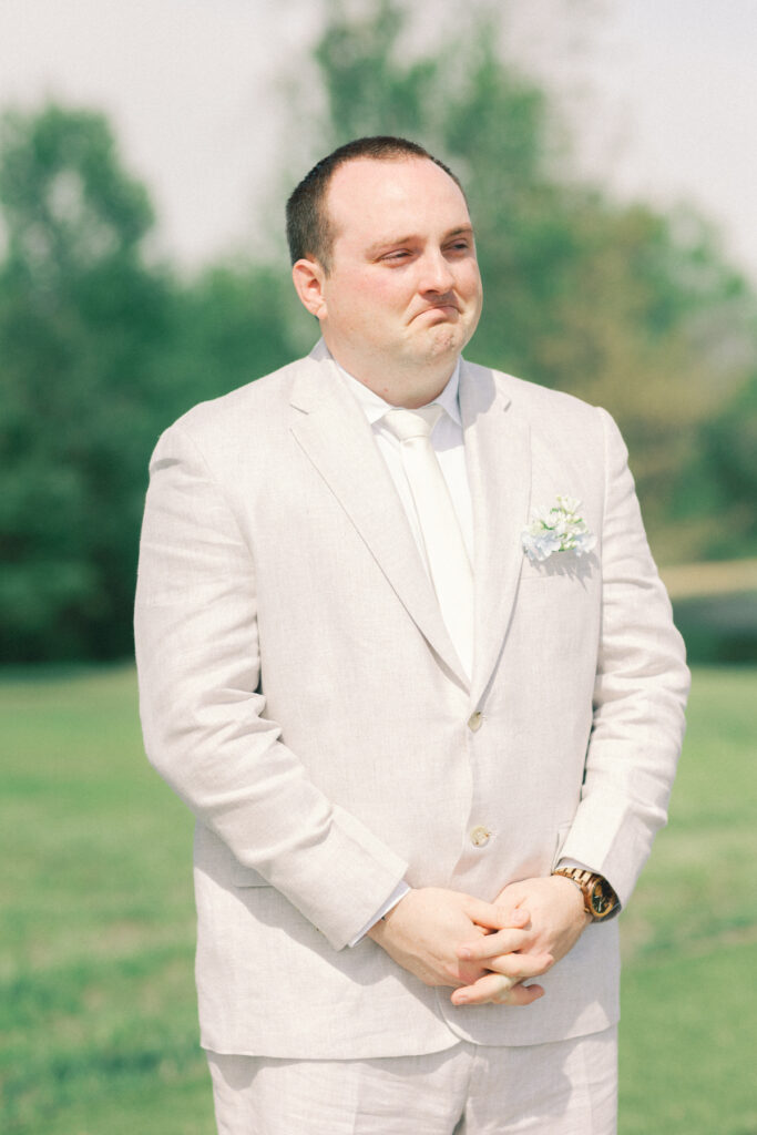 groom reacting to bride coming down aisle