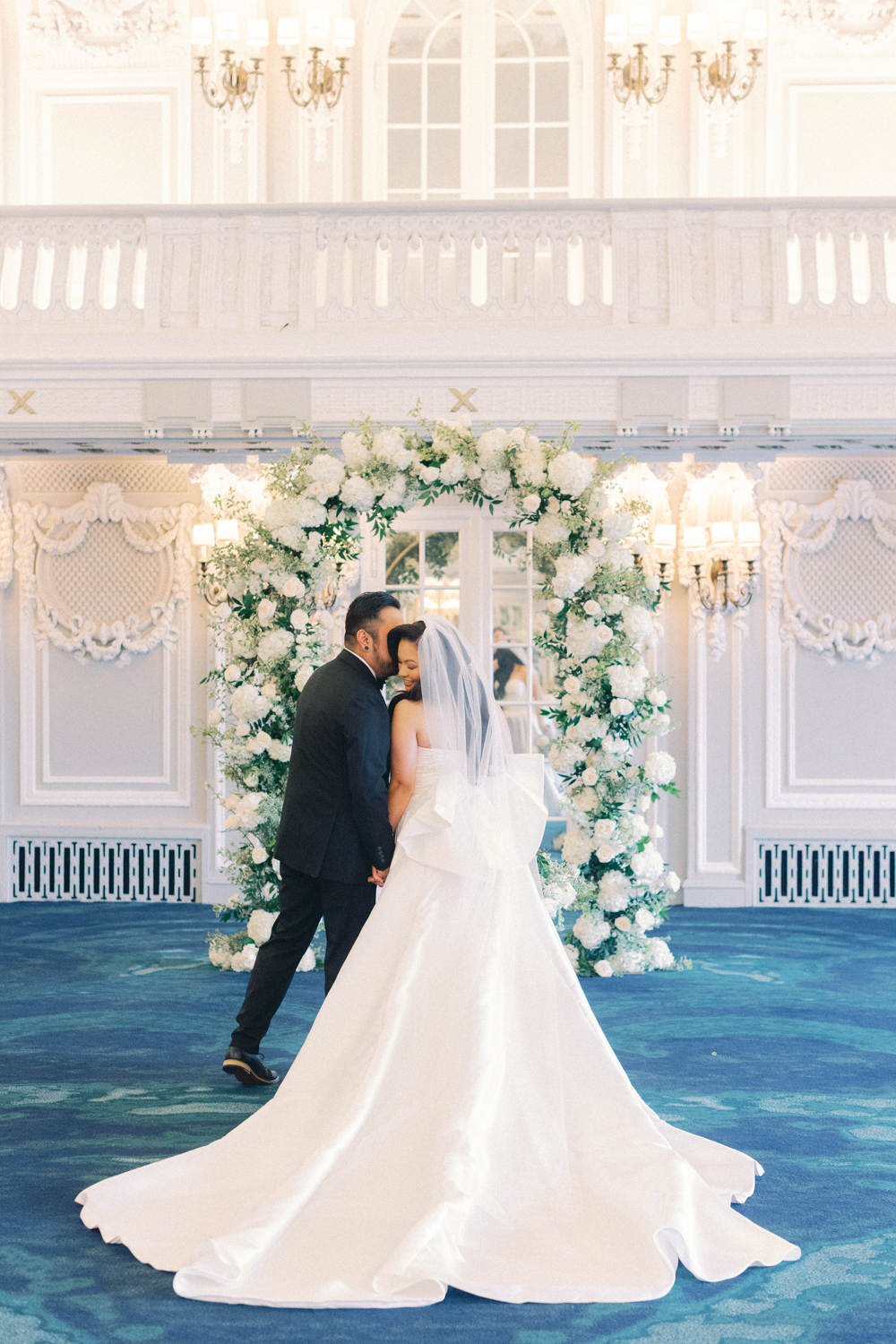 couple kissing in front of arch