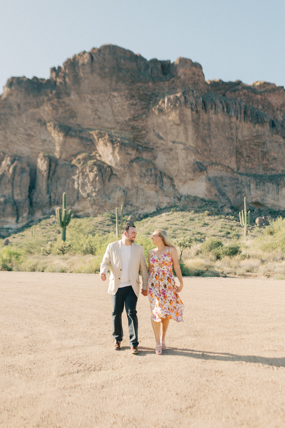 couple walking in desert and in front of mountain
