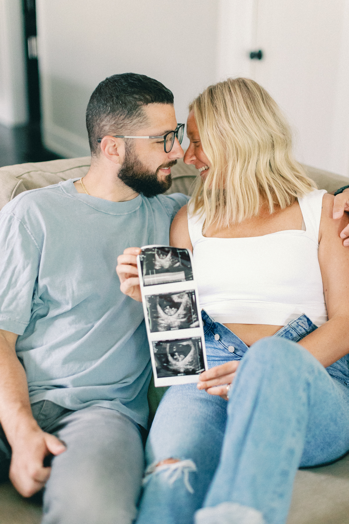couple snuggling and holding ultrasound picture