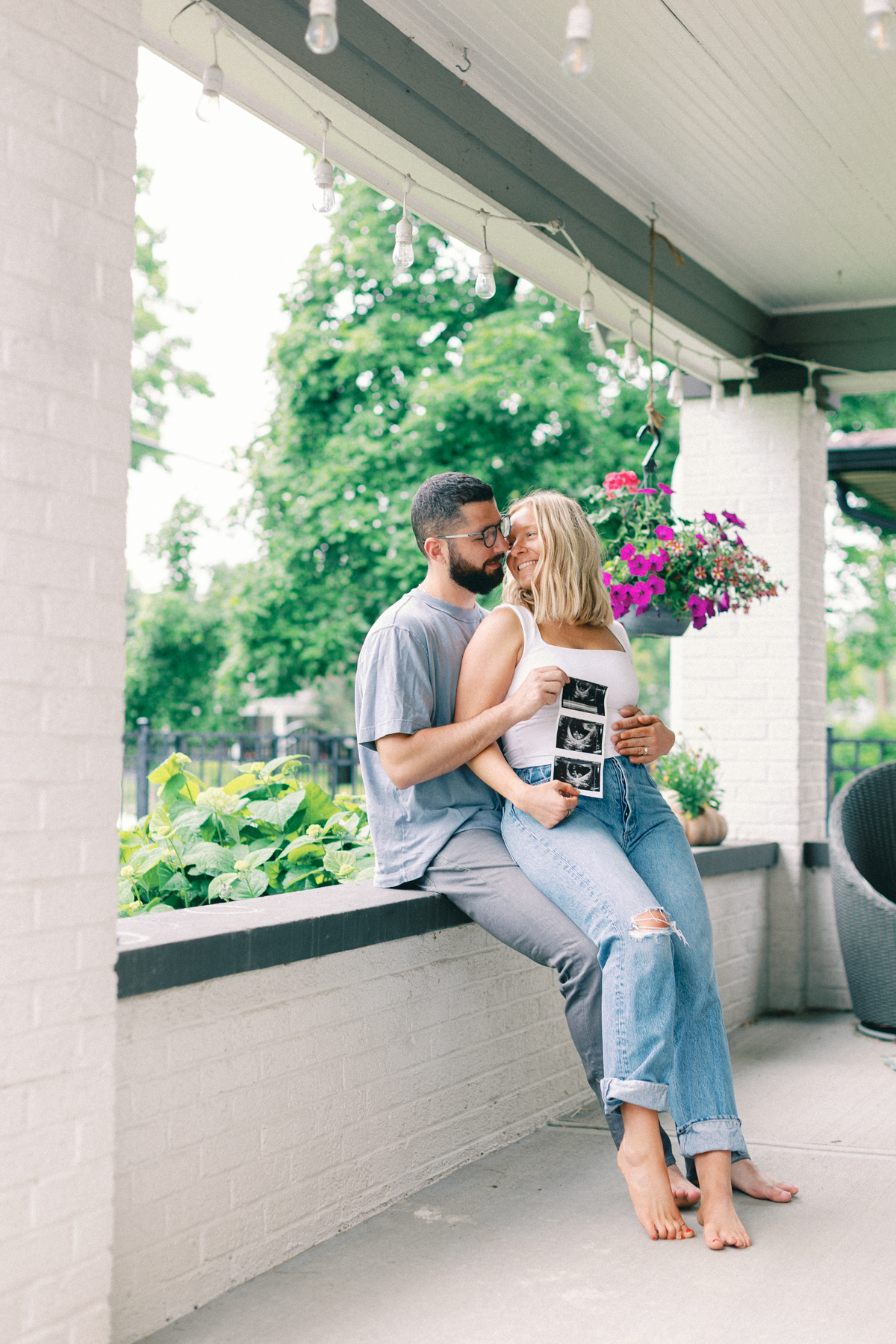 couple outside on porch holding ultrasound picture