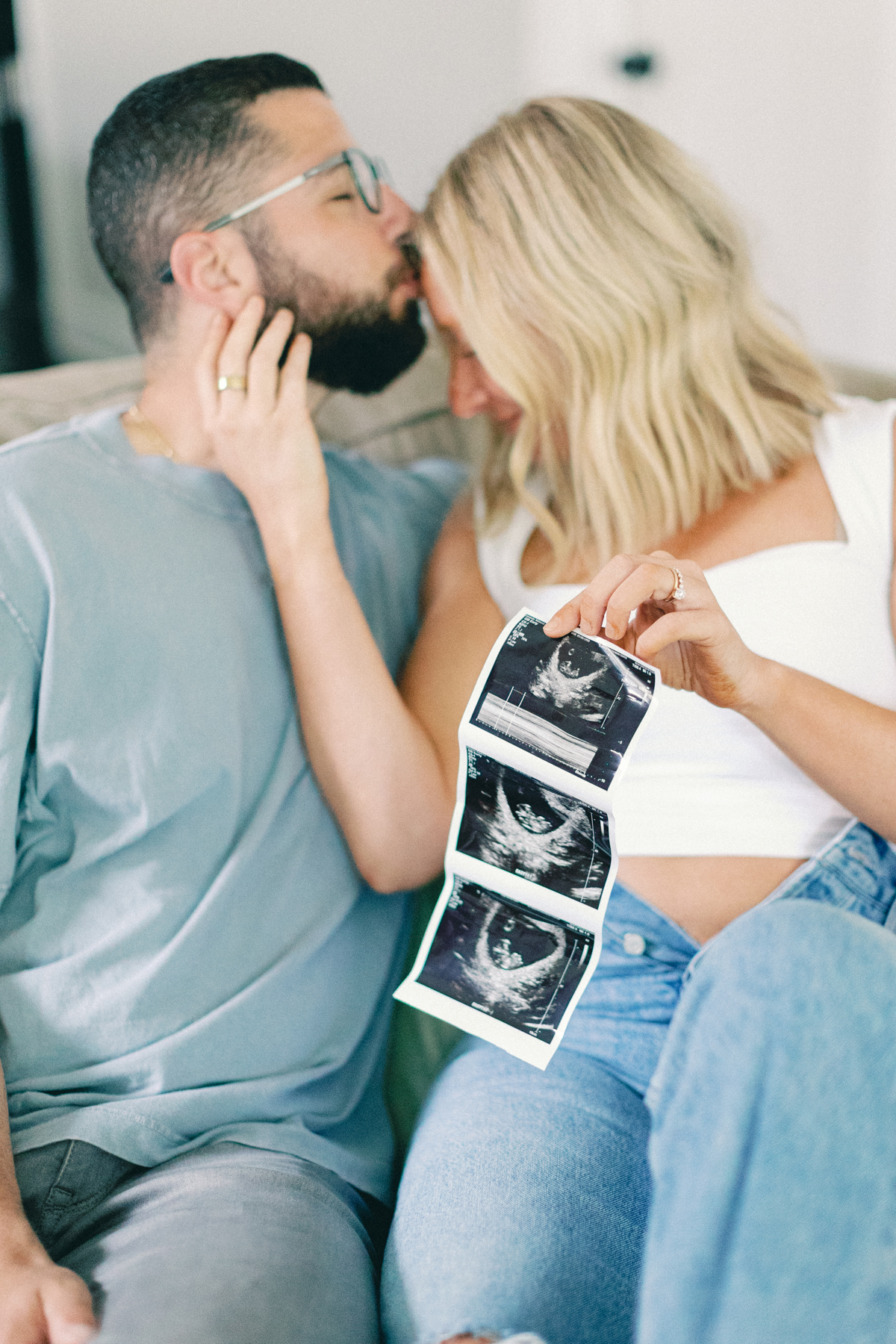 couple snuggling and kissing with ultrasound picture