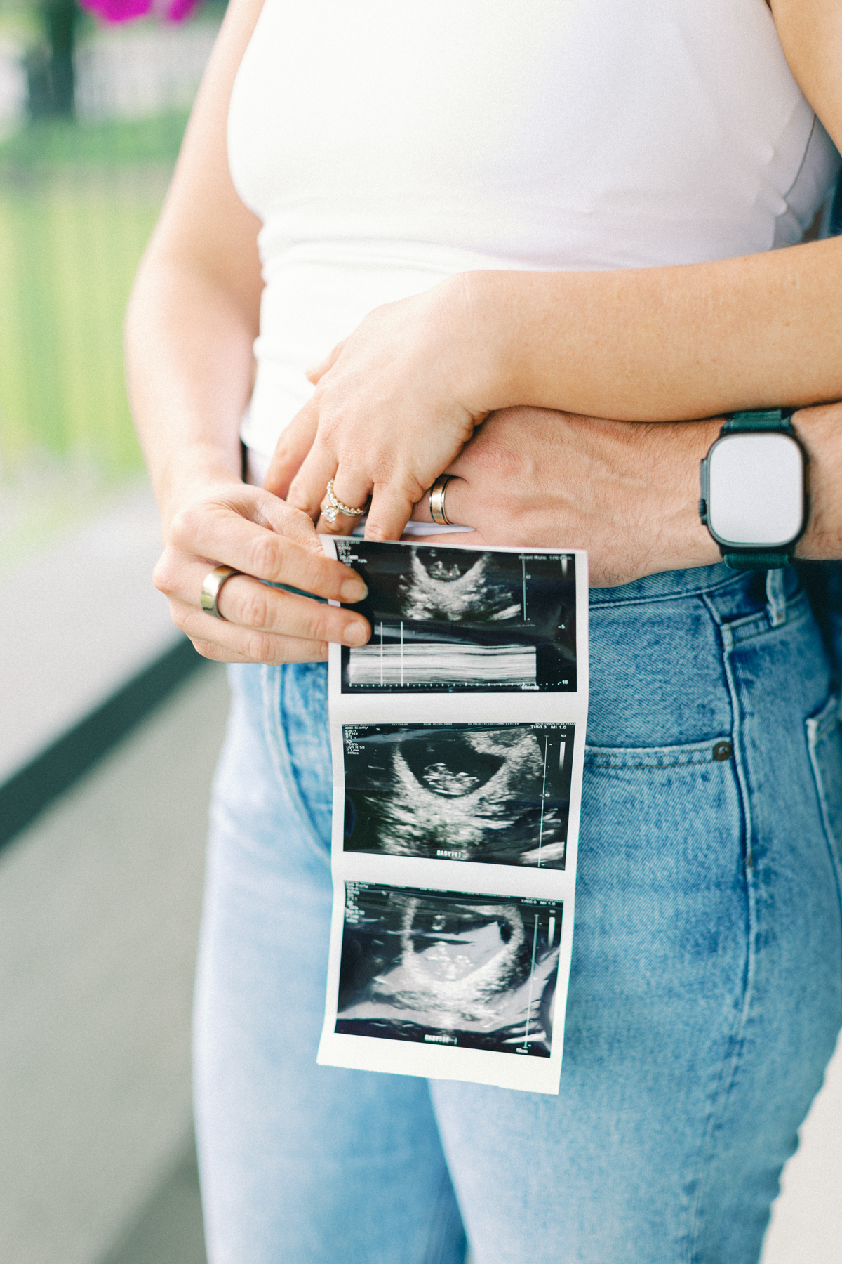 couple outside on porch holding ultrasound picture