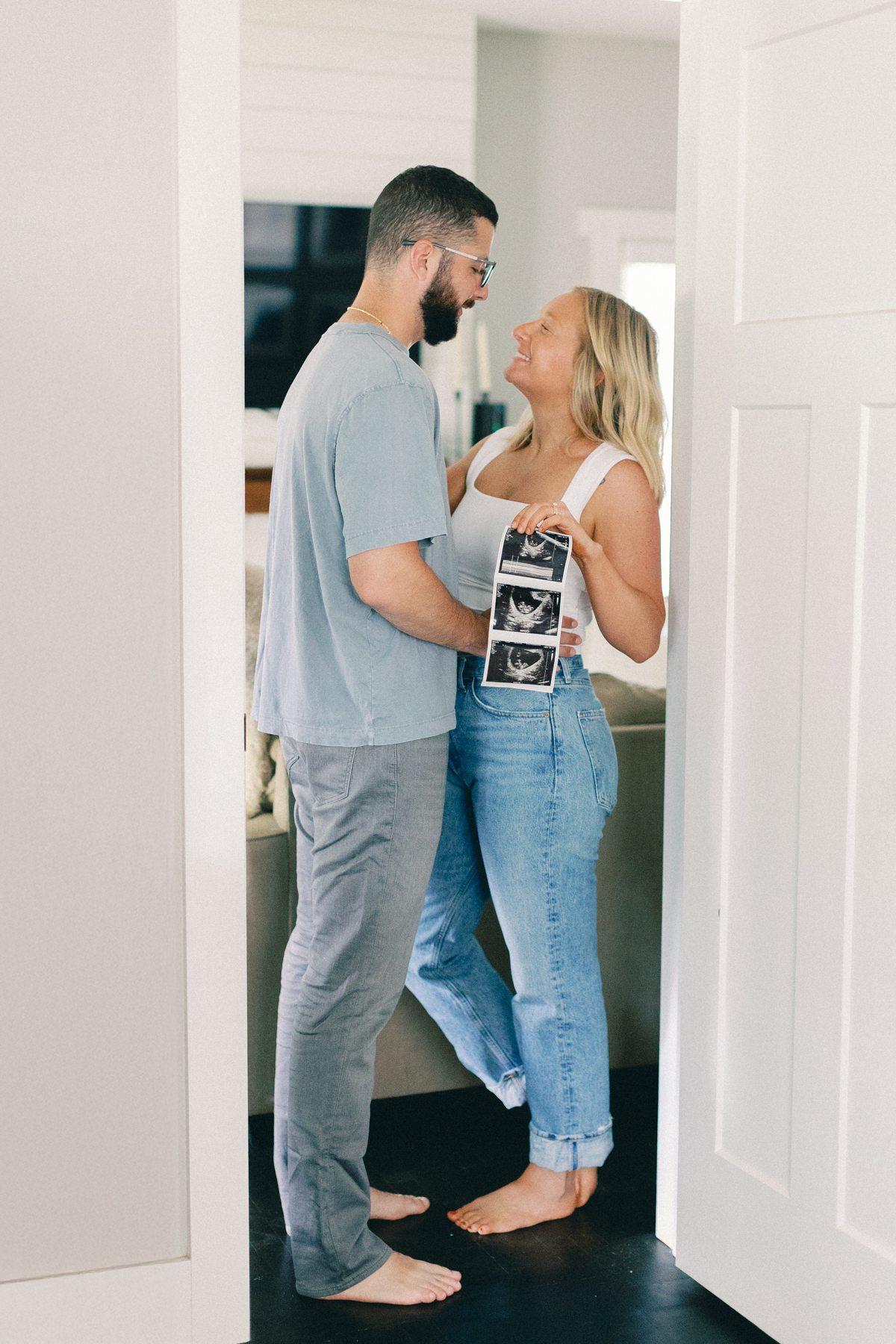 couple in doorway holding ultrasound picture