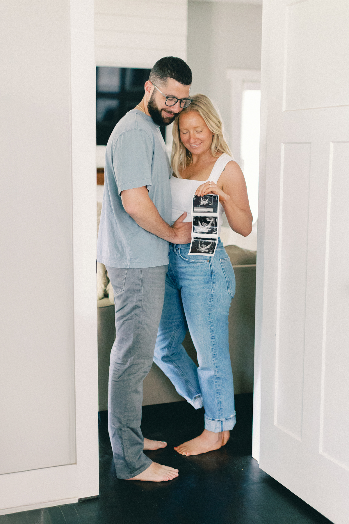 couple in doorway holding ultrasound picture