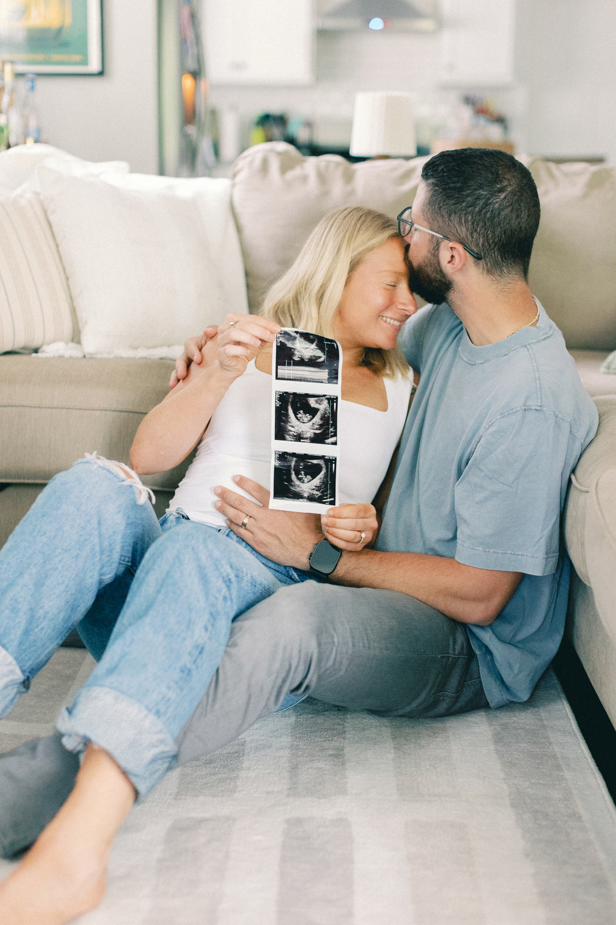 couple sitting on floor with ultrasound picture