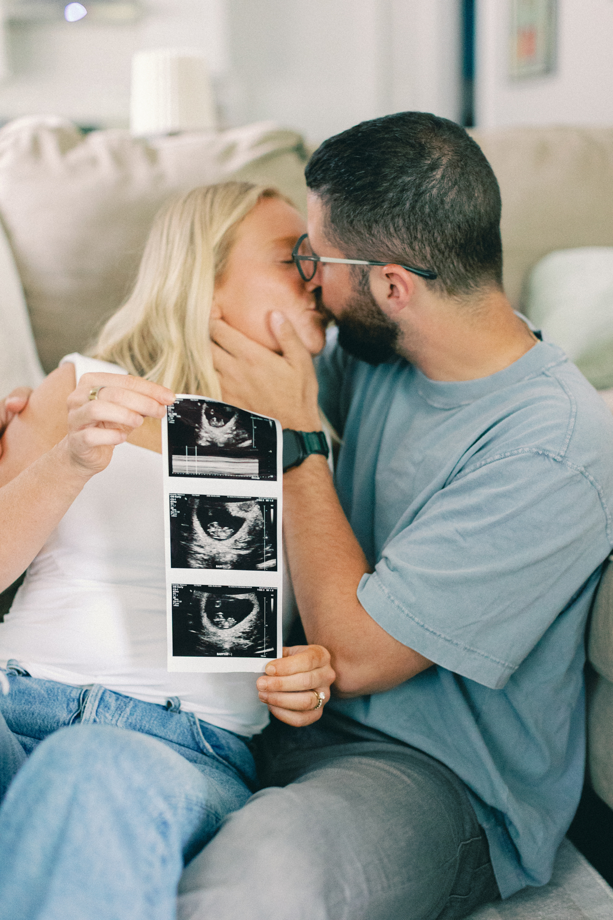 couple kissing holding ultrasound picture