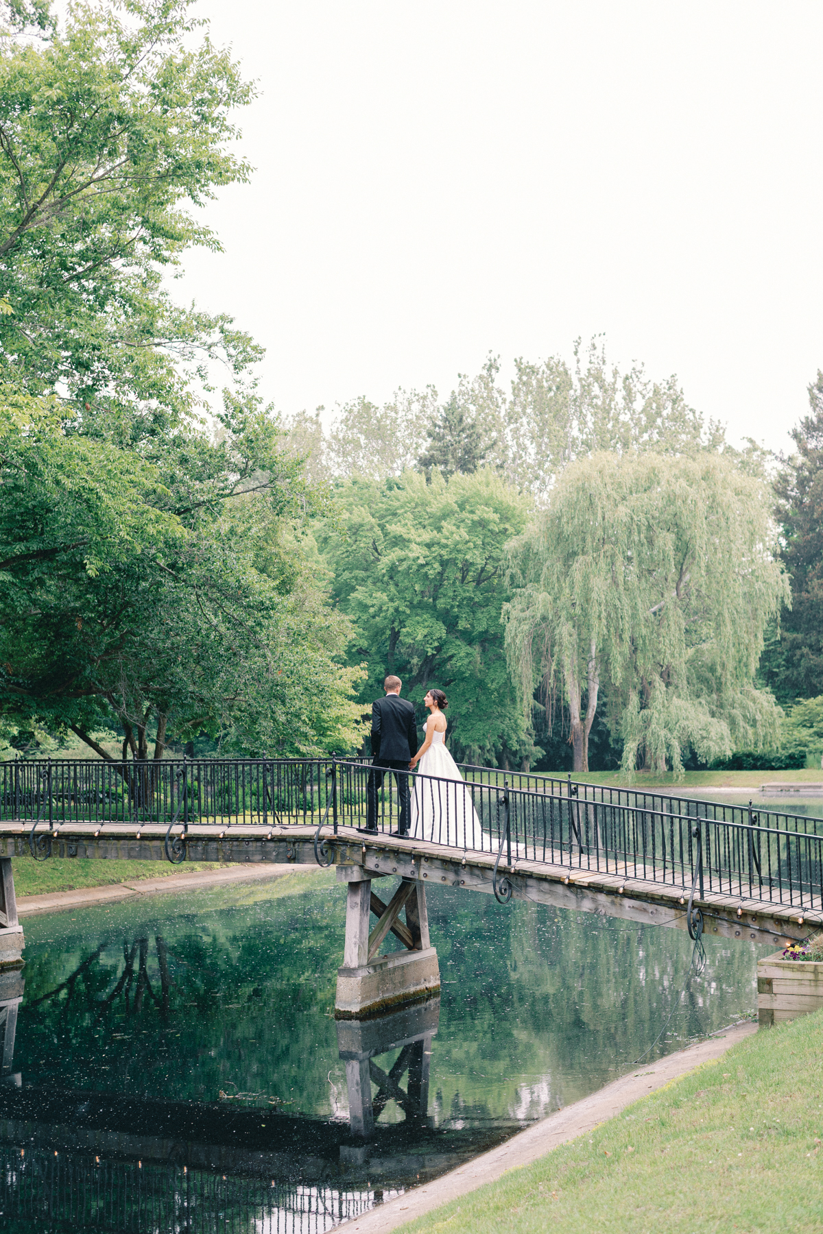 bride and groom walking on bridge