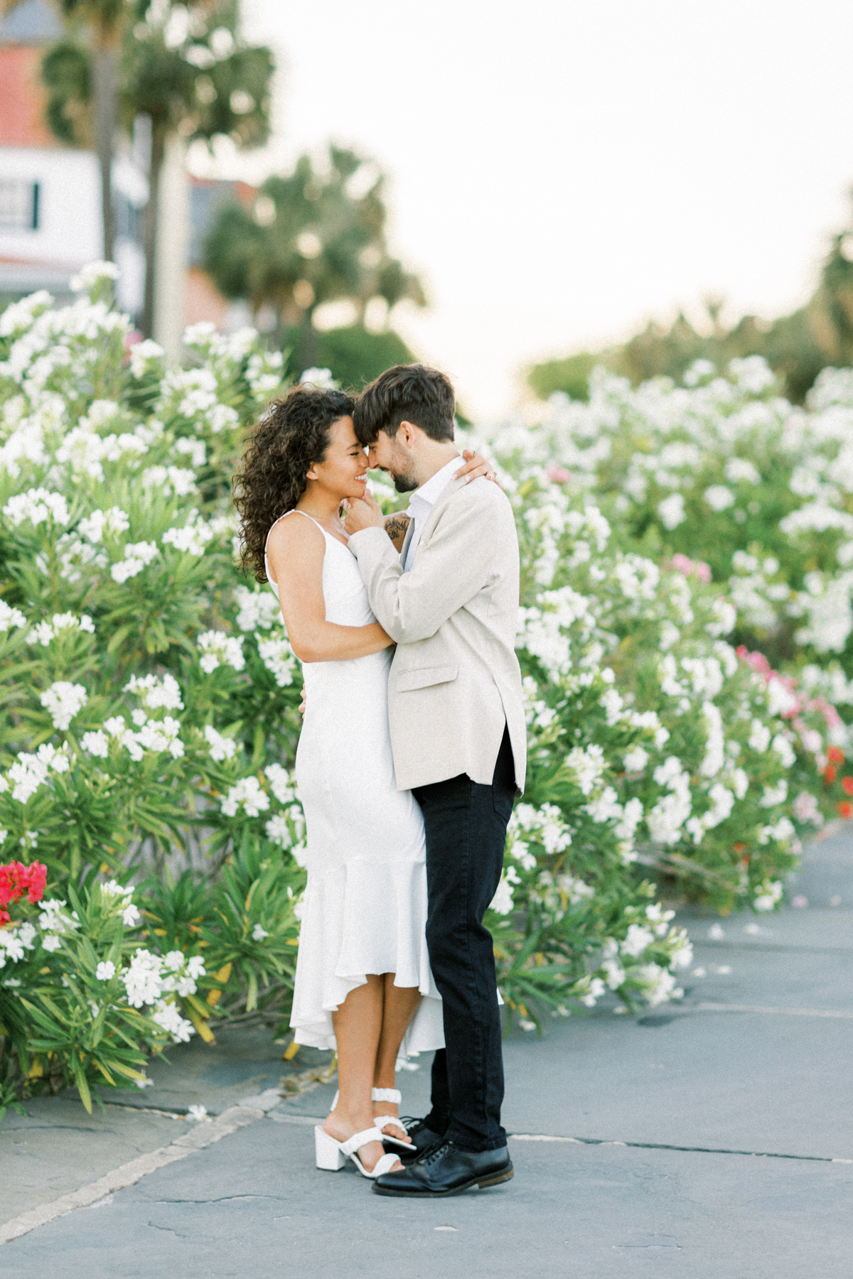 couple snuggling by trees