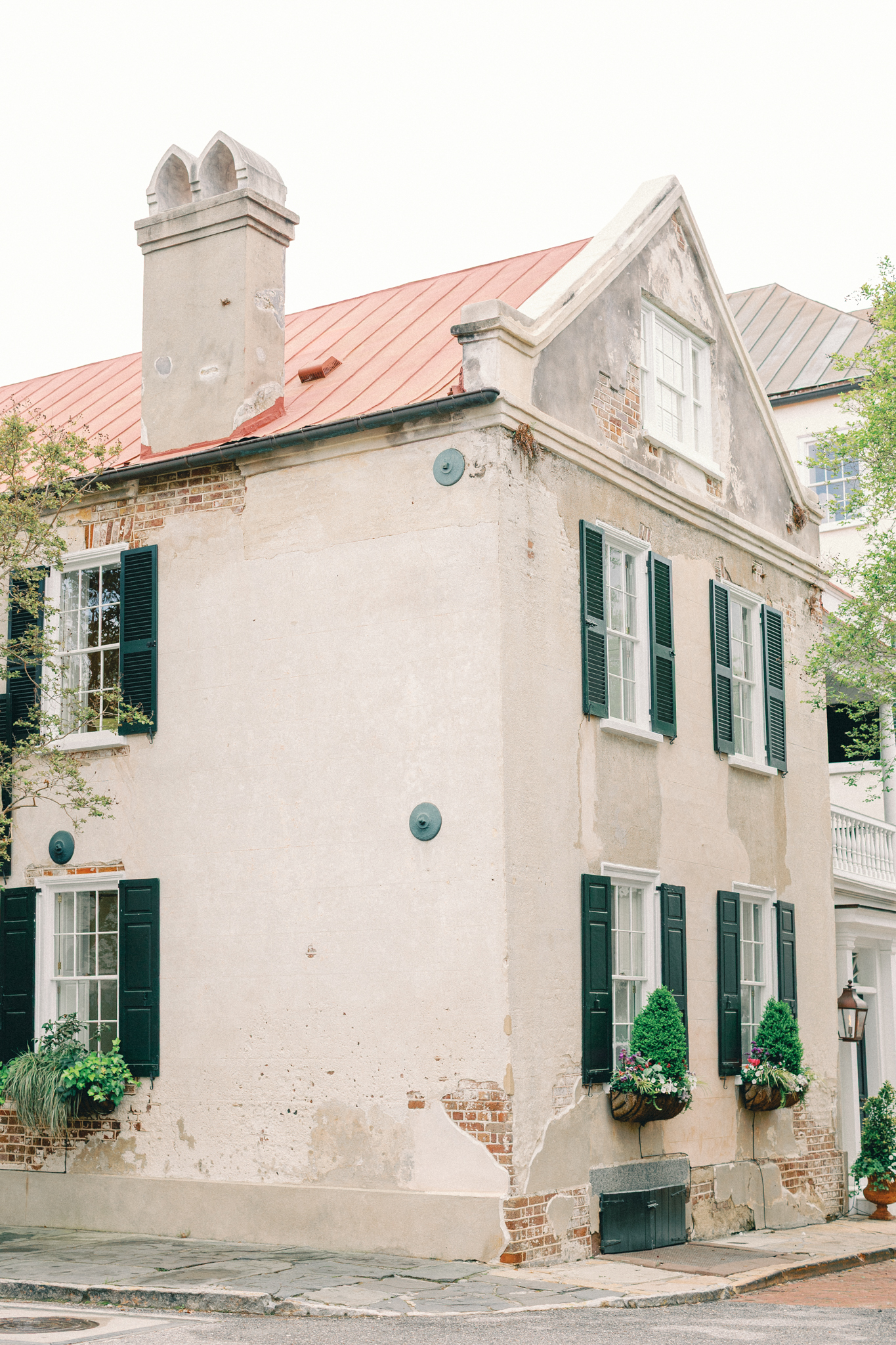 Historic French Quarter home in Charleston with green shutters and a red tin roof, a classic backdrop for Charleston engagement photos
