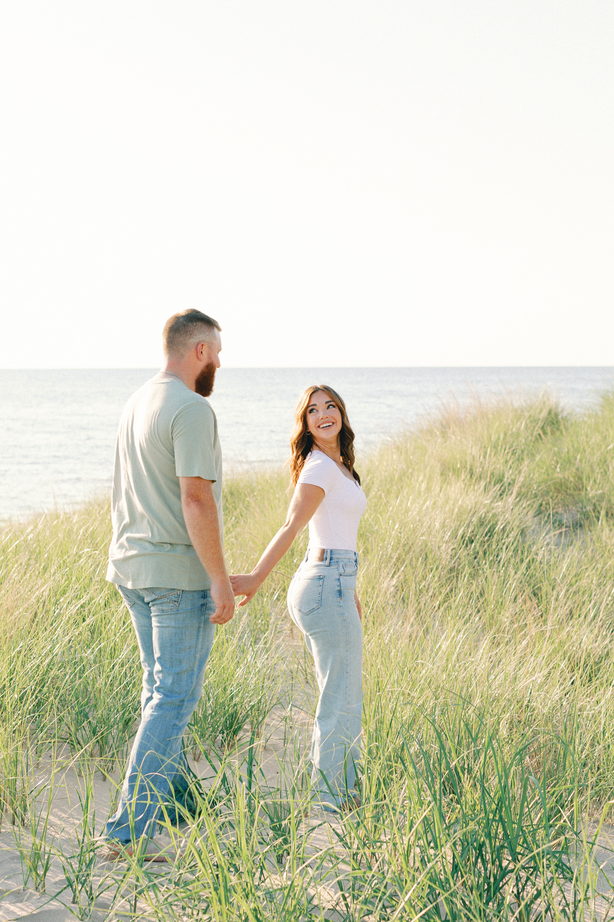 bride leading groom in field