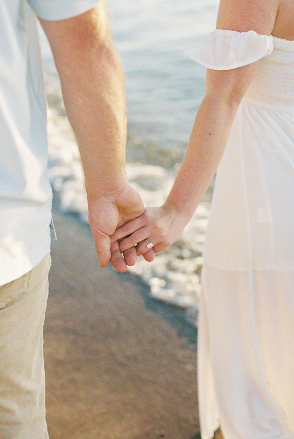 couples hands on beach shore