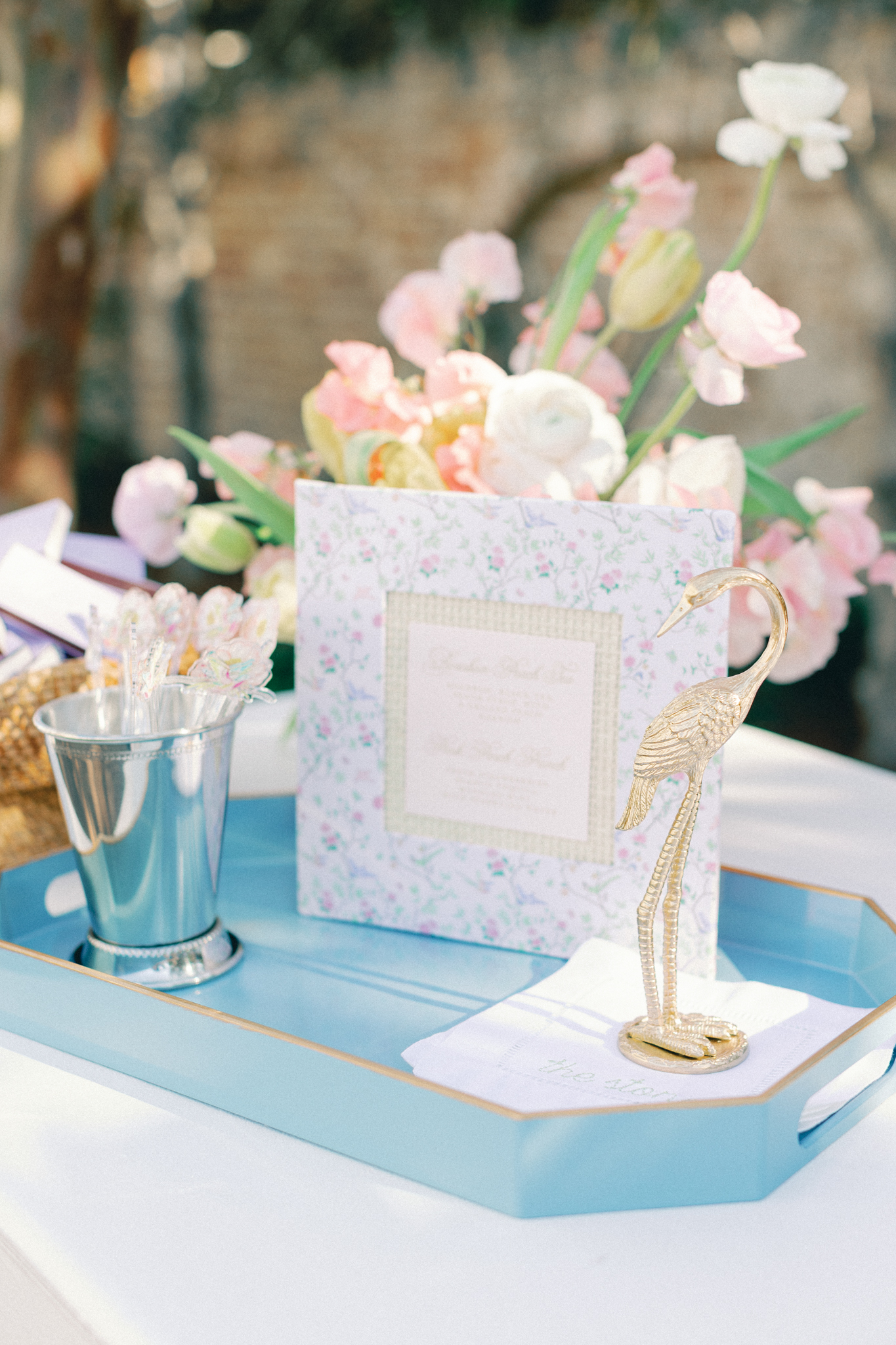 Blue tray with a chinoiserie welcome folder and mint julep cups, a styling detail from a Charleston wedding planner
