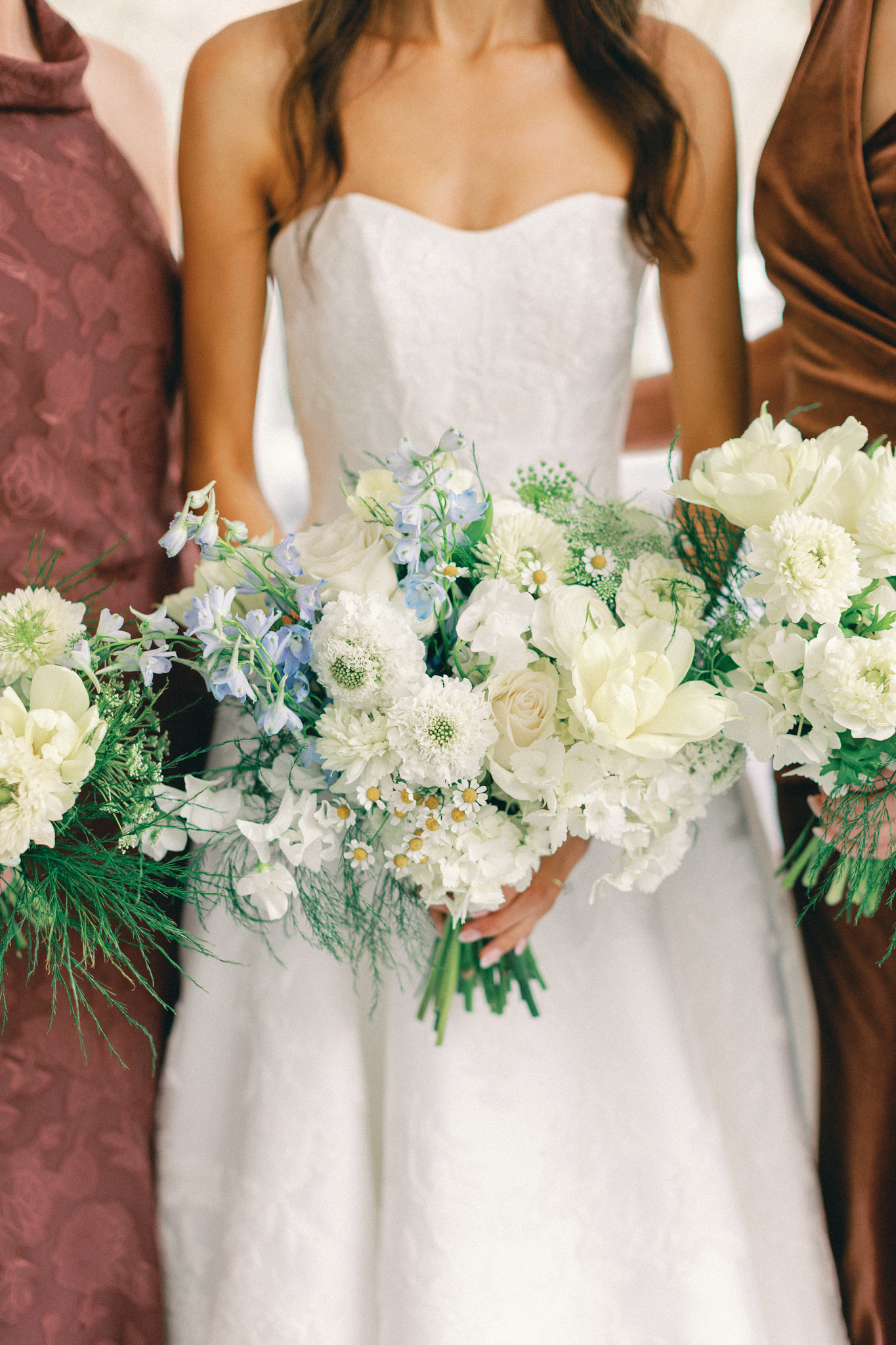 Bride and bridesmaids holding white and blue bouquets in a close-up at a Charleston wedding