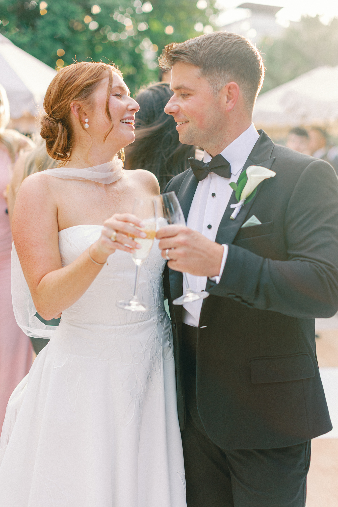 Bride and groom toasting champagne, groom in a tuxedo with a calla boutonniere, at a Charleston wedding reception