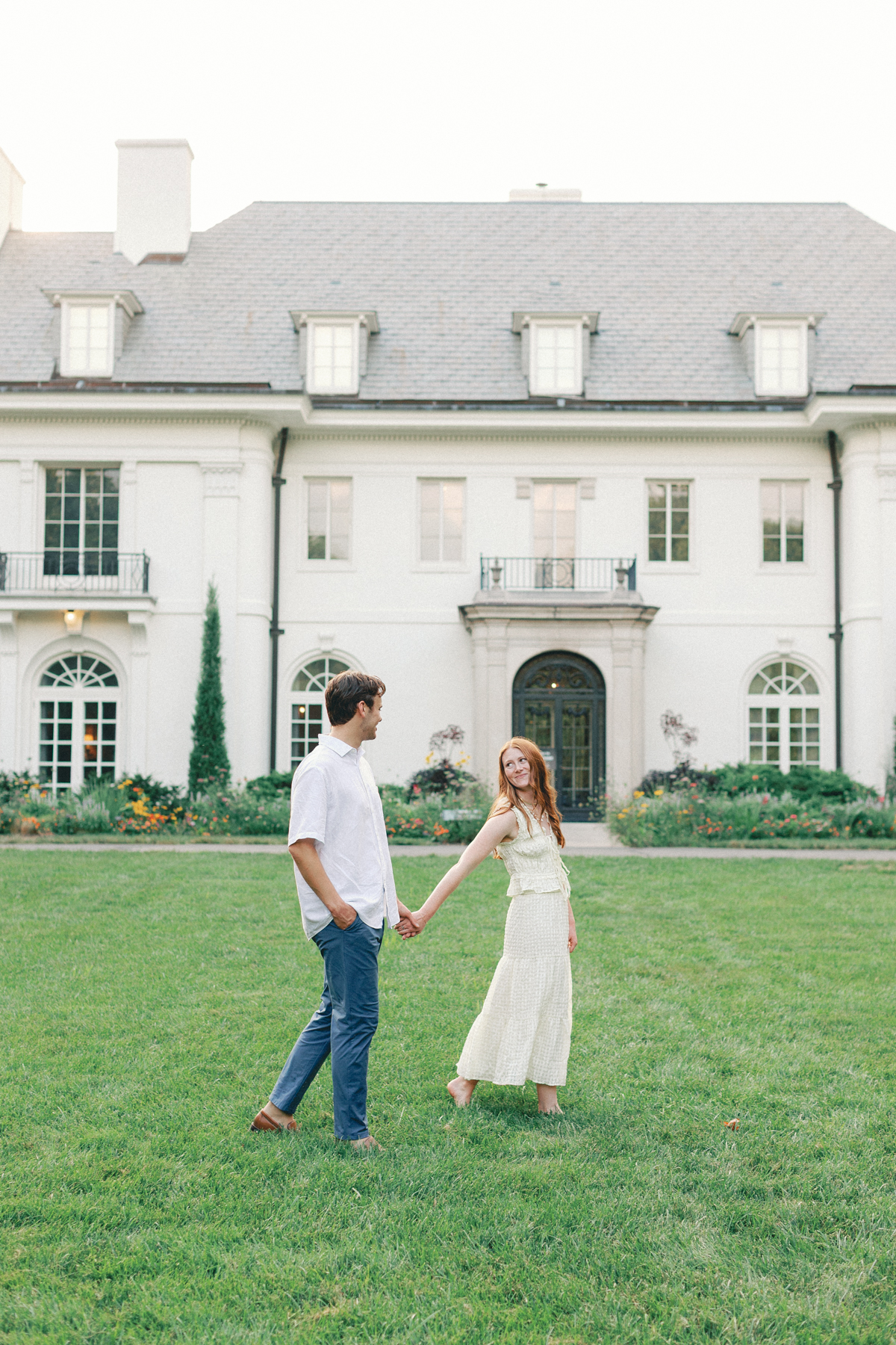 Couple walking in front of mansion