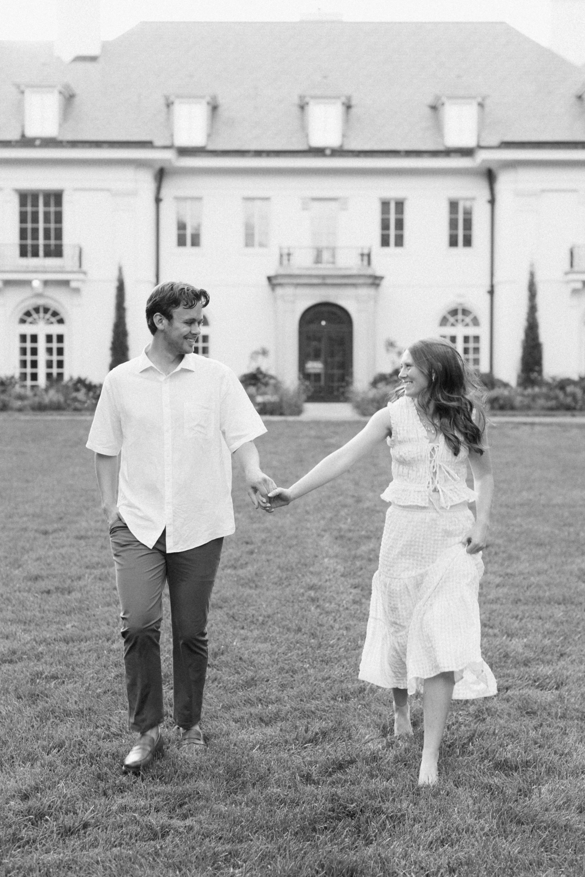 Black and white photo of couple running towards camera