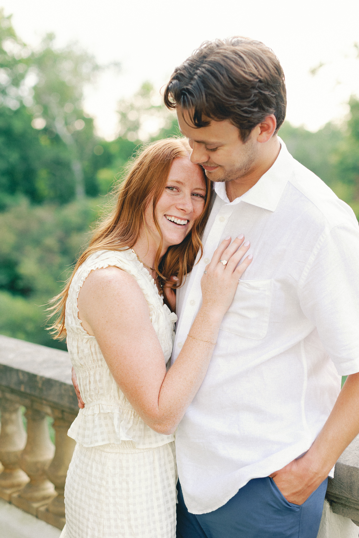  bride looking at camera while groom kisses