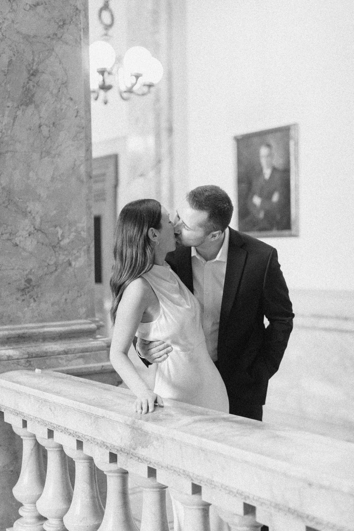 Black-and-white photo of the couple kissing in library