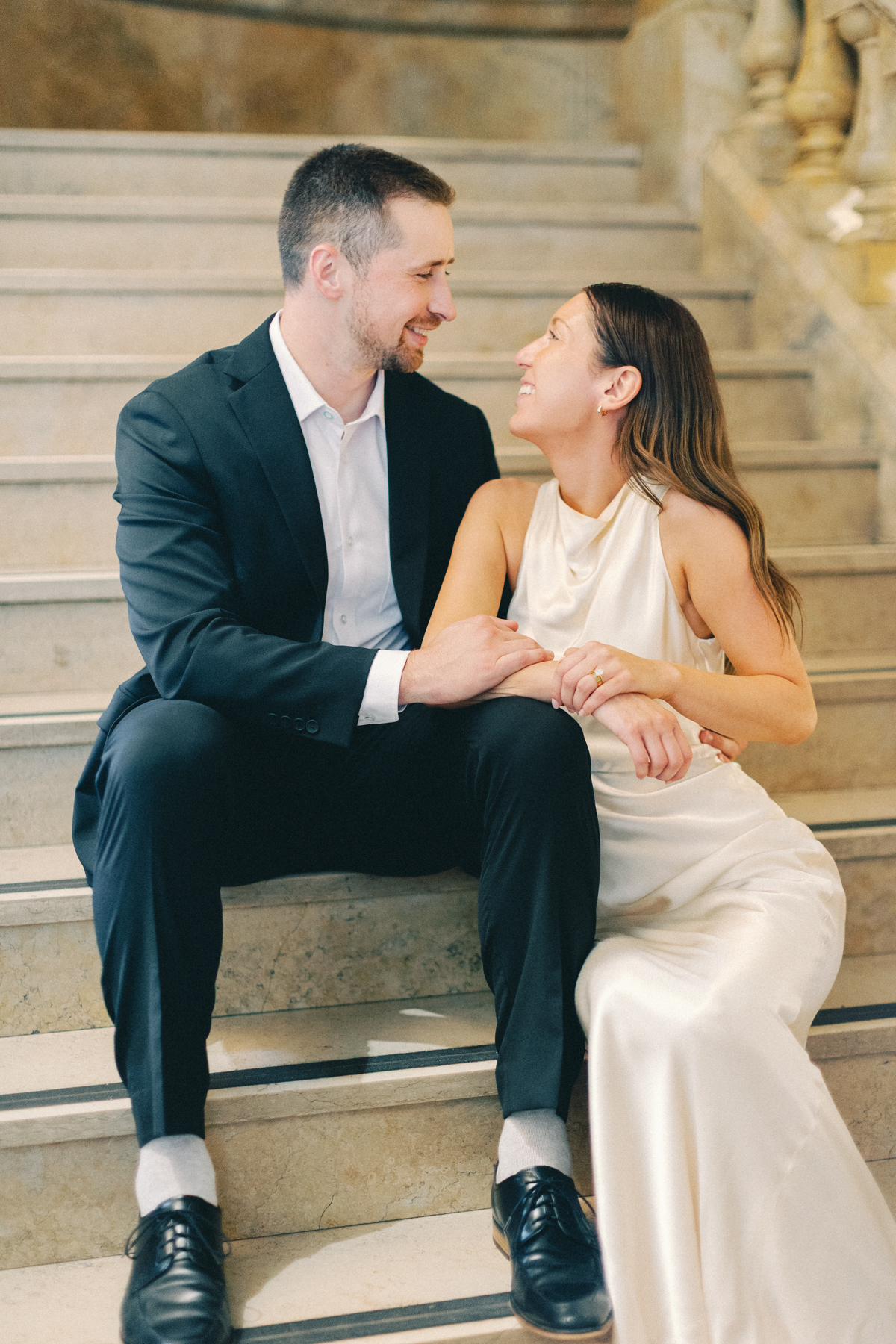 Couple sitting on library steps, laughing
