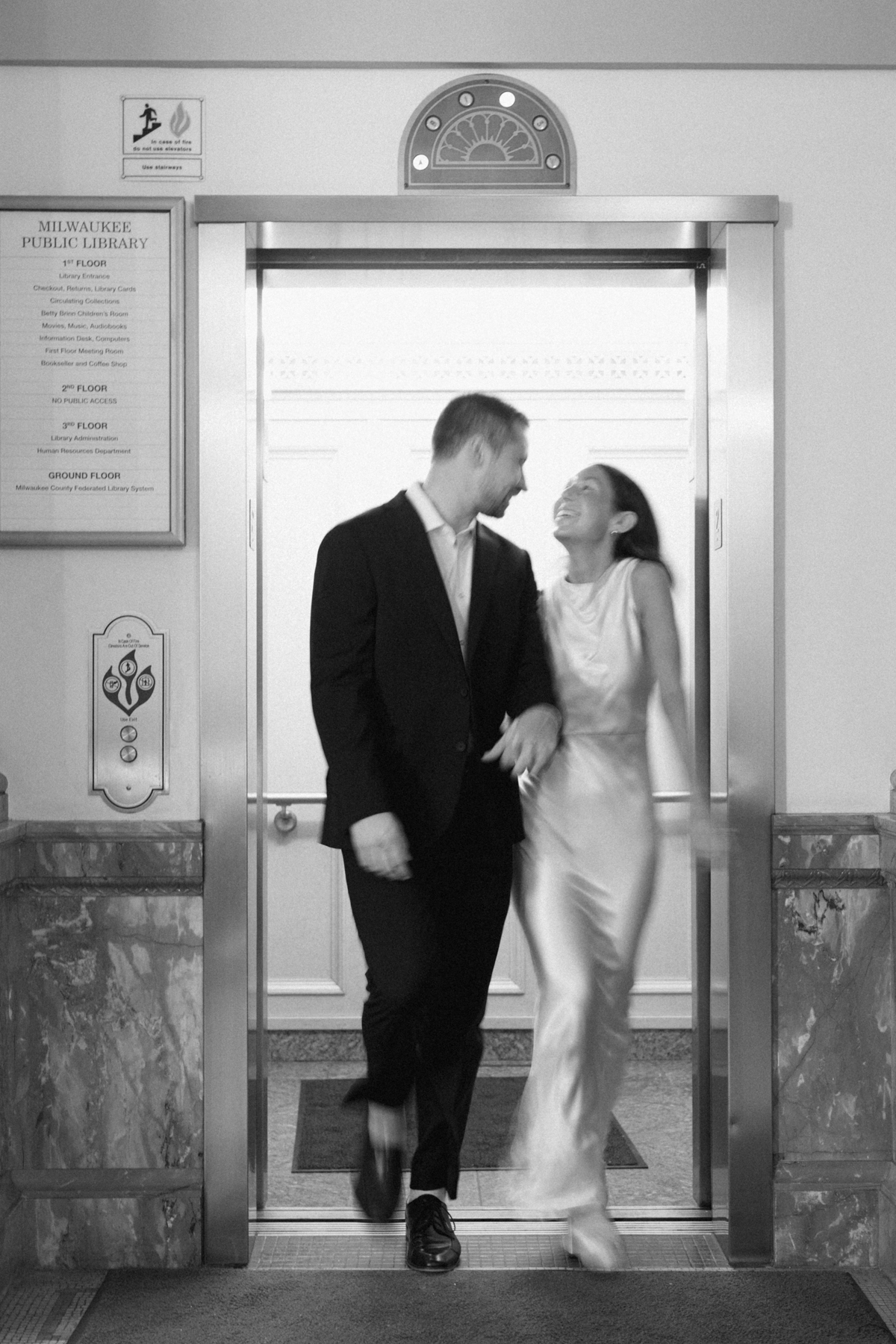 Black-and-white photo of couple exiting elevator