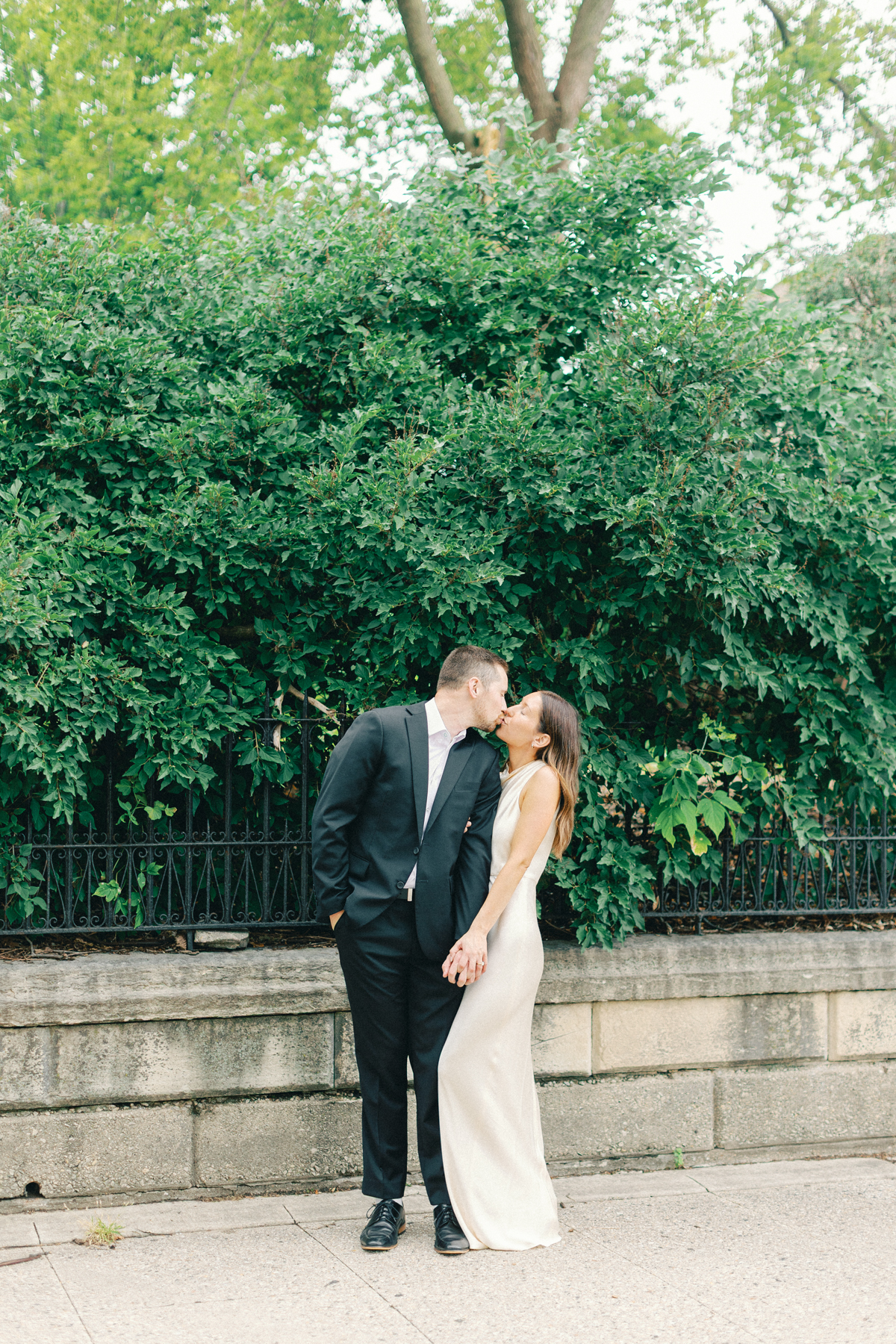Couple snuggled on the sidewalk, kissing