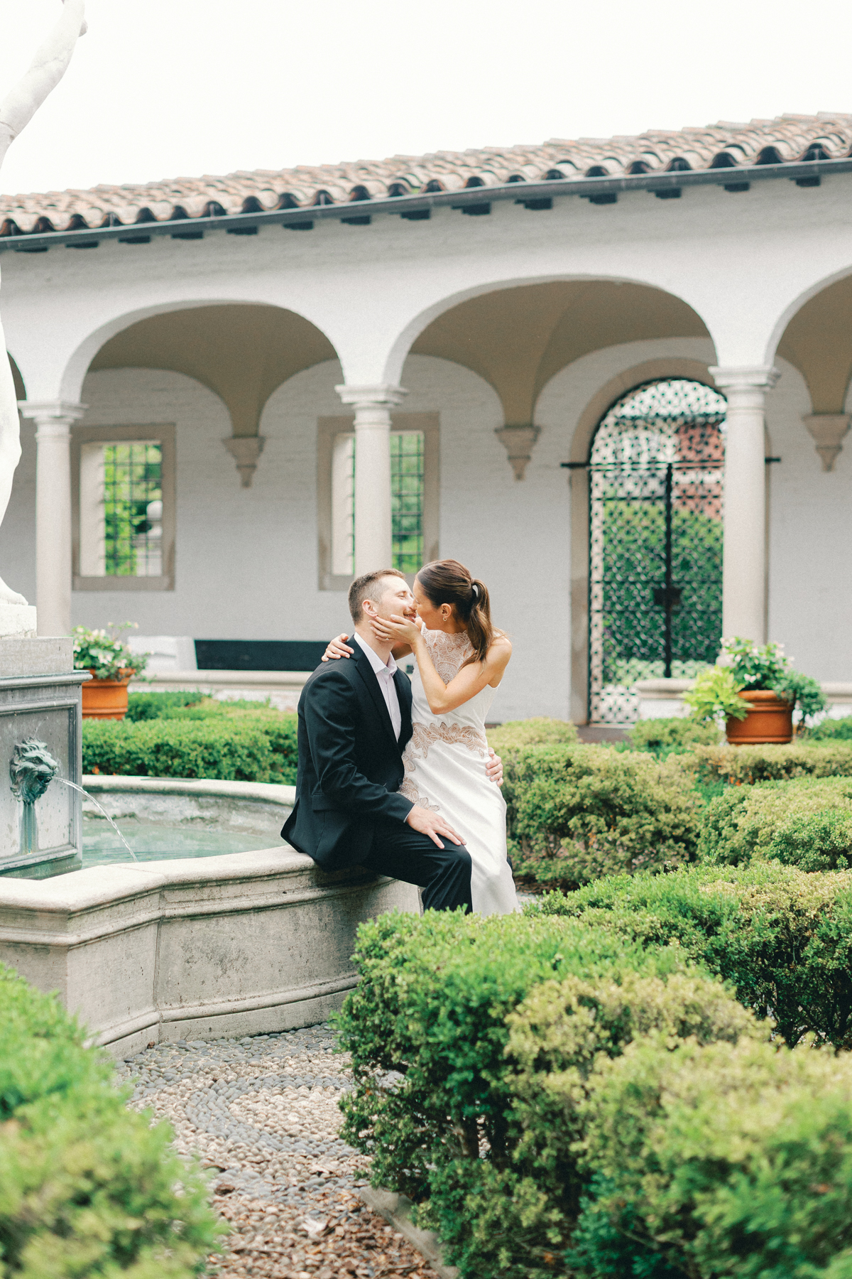 Couples sitting on fountain, kissing