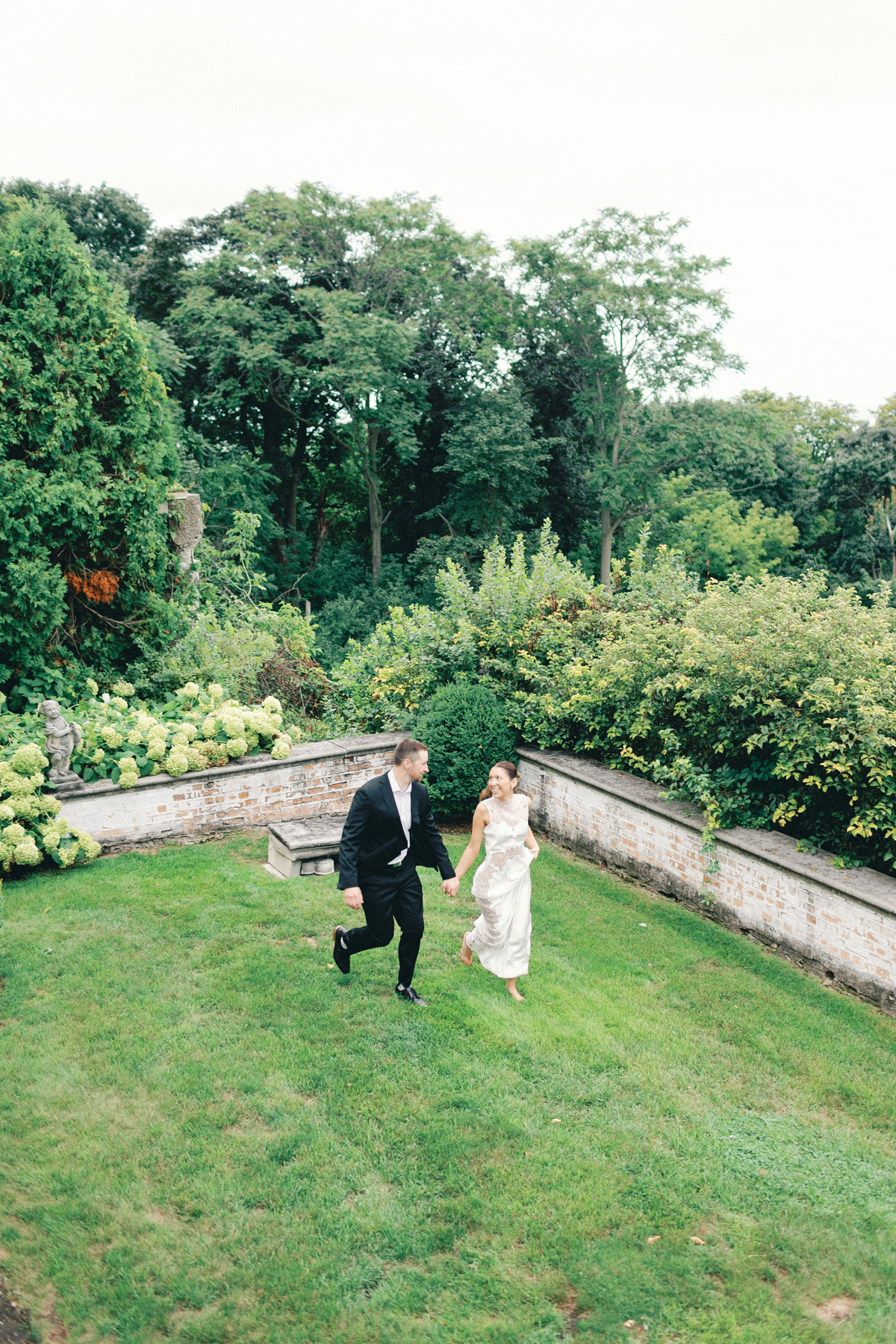 Couple running in gardens aerial view