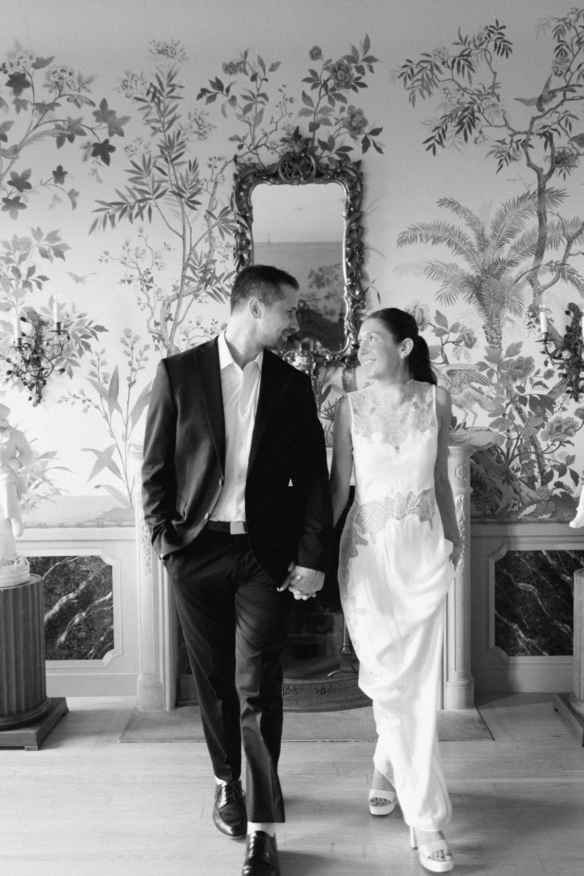 Couple walking towards camera in black-and-white inside