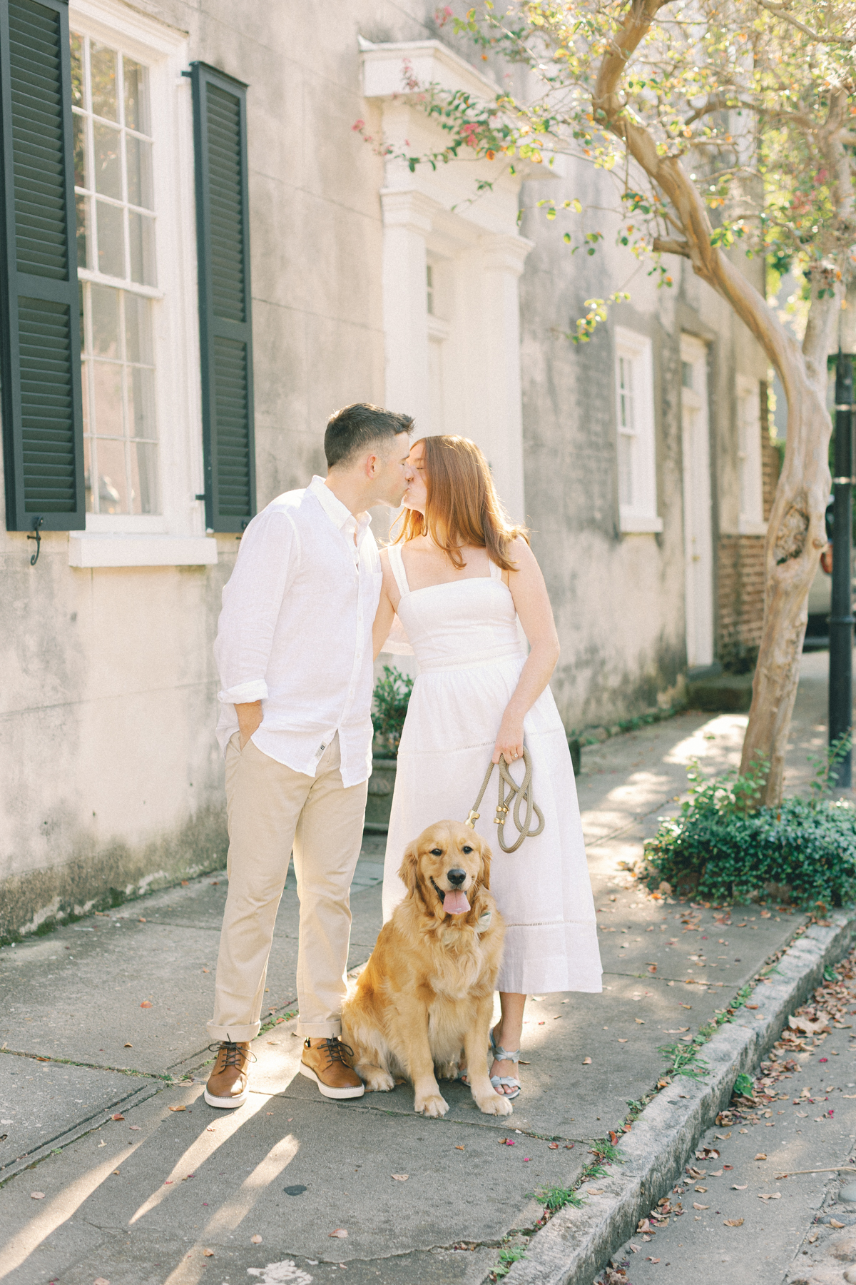 Couple kissing with their dog