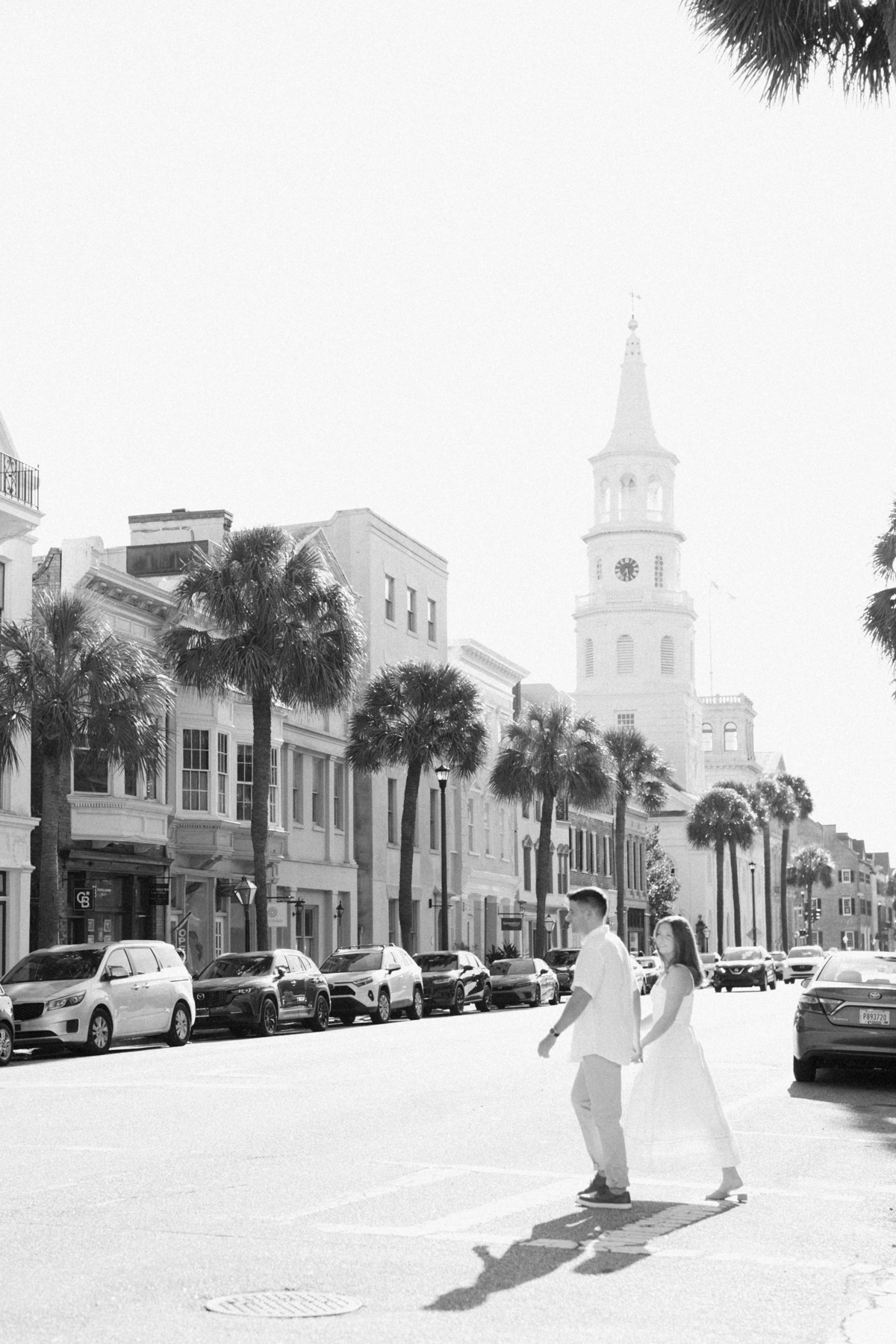 Black-and-white photo of couple walking across the road
