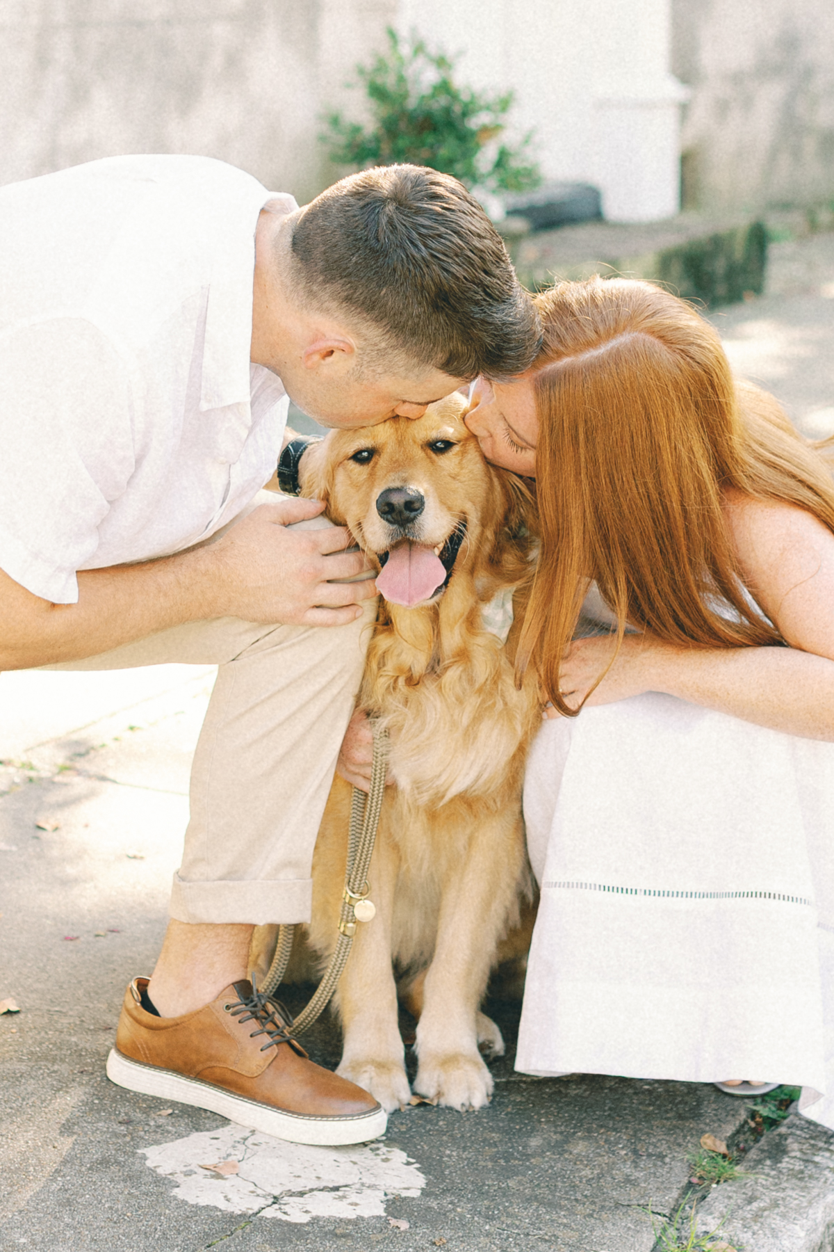 Couple kissing their dog